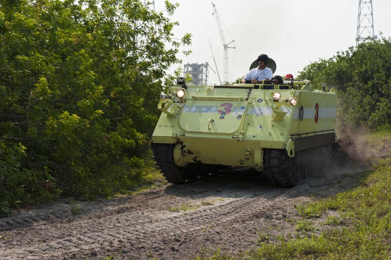 CAPE CANAVERAL, Fla. -- Battalion Chief David Seymour provides supervision while space shuttle Atlantis' STS-135 crew members participate in M113 armored personnel carrier training at NASA's Kennedy Space Center in Florida. Driving the M113 is Mission Specialist Sandy Magnus while Pilot Doug Hurley looks on. An M113 is kept at the foot of the launch pad in case an emergency exit from the launch pad is needed and every shuttle crew is trained on driving the vehicle before launch. The STS-135 crew is at Kennedy to participate in a launch countdown dress rehearsal called the Terminal Countdown Demonstration Test (TCDT) and related training.                Atlantis and its crew are targeted to lift off July 8, taking with them the Raffaello multi-purpose logistics module packed with supplies and spare parts to the International Space Station. The STS-135 mission also will fly a system to investigate the potential for robotically refueling existing satellites and return a failed ammonia pump module to help NASA better understand the failure mechanism and improve pump designs for future systems. STS-135 will be the 33rd flight of Atlantis, the 37th shuttle mission to the space station, and the 135th and final mission of NASA's Space Shuttle Program. For more information visit, www.nasa.gov/mission_pages/shuttle/shuttlemissions/sts135/index.html. Photo credit: NASA/Kim Shiflett