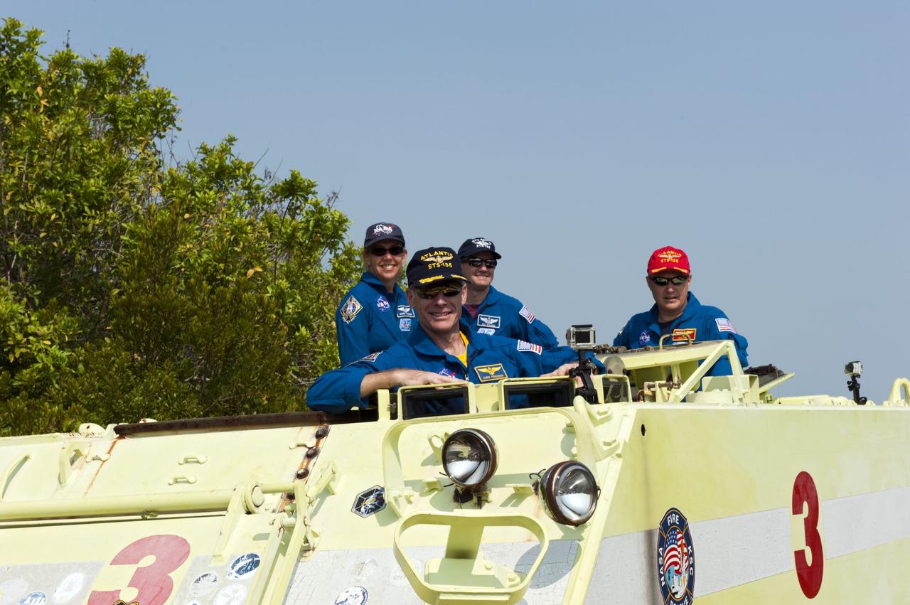 CAPE CANAVERAL, Fla. -- The STS-135 crew pause for a photo during their M113 armored personnel carrier training at NASA's Kennedy Space Center in Florida. Seen here are Commander Chris Ferguson (front), Mission Specialists Sandy Magnus, Rex Walheim and Pilot Doug Hurley (red cap). An M113 is kept at the foot of the launch pad in case an emergency exit from the launch pad is needed and every shuttle crew is trained on driving the vehicle before launch. The STS-135 crew is at Kennedy to participate in a launch countdown dress rehearsal called the Terminal Countdown Demonstration Test (TCDT) and related training.          Atlantis and its crew are targeted to lift off July 8, taking with them the Raffaello multi-purpose logistics module packed with supplies and spare parts to the International Space Station. The STS-135 mission also will fly a system to investigate the potential for robotically refueling existing satellites and return a failed ammonia pump module to help NASA better understand the failure mechanism and improve pump designs for future systems. STS-135 will be the 33rd flight of Atlantis, the 37th shuttle mission to the space station, and the 135th and final mission of NASA's Space Shuttle Program. For more information visit, www.nasa.gov/mission_pages/shuttle/shuttlemissions/sts135/index.html. Photo credit: NASA/Kim Shiflett