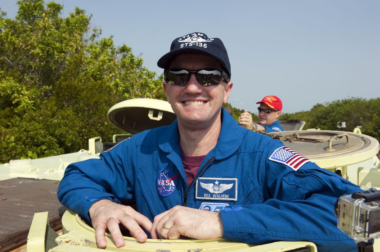 CAPE CANAVERAL, Fla. -- Mission Specialist Rex Walheim pauses for a photo during M113 armored personnel carrier training at NASA's Kennedy Space Center in Florida. Behind Walheim is Pilot Doug Hurley. An M113 is kept at the foot of the launch pad in case an emergency exit from the launch pad is needed and every shuttle crew is trained on driving the vehicle before launch. The STS-135 crew is at Kennedy to participate in a launch countdown dress rehearsal called the Terminal Countdown Demonstration Test (TCDT) and related training. Atlantis and its crew are targeted to lift off July 8, taking with them the Raffaello multi-purpose logistics module packed with supplies and spare parts to the International Space Station. The STS-135 mission also will fly a system to investigate the potential for robotically refueling existing satellites and return a failed ammonia pump module to help NASA better understand the failure mechanism and improve pump designs for future systems. STS-135 will be the 33rd flight of Atlantis, the 37th shuttle mission to the space station, and the 135th and final mission of NASA's Space Shuttle Program. For more information visit, www.nasa.gov/mission_pages/shuttle/shuttlemissions/sts135/index.html. Photo credit: NASA/Kim Shiflett