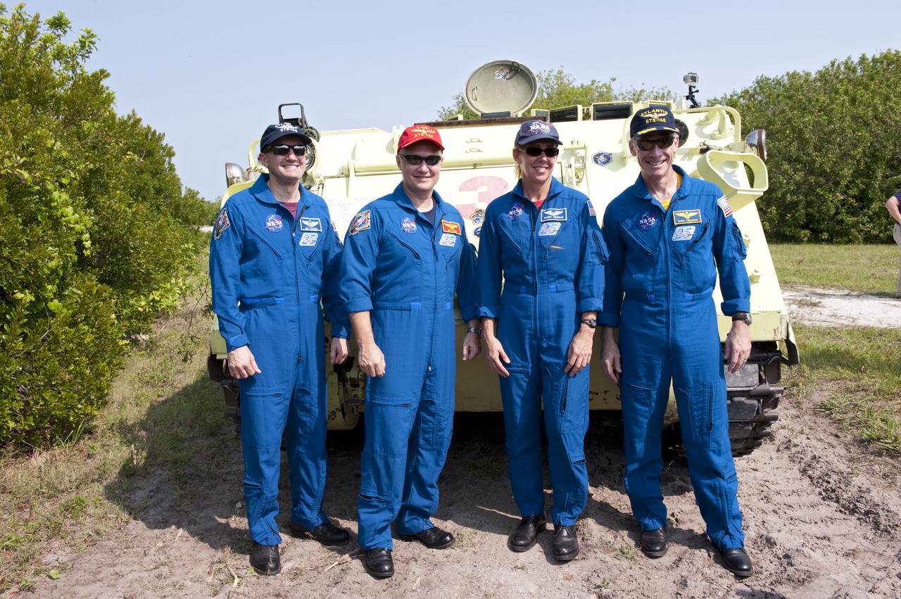 CAPE CANAVERAL, Fla. -- The STS-135 crew pause for a photo at the conclusion of their M113 armored personnel carrier training at NASA's Kennedy Space Center in Florida. Seen here are Mission Specialist Rex Walheim (left), Pilot Doug Hurley, Mission Specialist Sandy Magnus and Commander Chris Ferguson. An M113 is kept at the foot of the launch pad in case an emergency exit from the launch pad is needed and every shuttle crew is trained on driving the vehicle before launch. The STS-135 crew is at Kennedy to participate in a launch countdown dress rehearsal called the Terminal Countdown Demonstration Test (TCDT) and related training.         Atlantis and its crew are targeted to lift off July 8, taking with them the Raffaello multi-purpose logistics module packed with supplies and spare parts to the International Space Station. The STS-135 mission also will fly a system to investigate the potential for robotically refueling existing satellites and return a failed ammonia pump module to help NASA better understand the failure mechanism and improve pump designs for future systems. STS-135 will be the 33rd flight of Atlantis, the 37th shuttle mission to the space station, and the 135th and final mission of NASA's Space Shuttle Program. For more information visit, www.nasa.gov/mission_pages/shuttle/shuttlemissions/sts135/index.html. Photo credit: NASA/Kim Shiflett