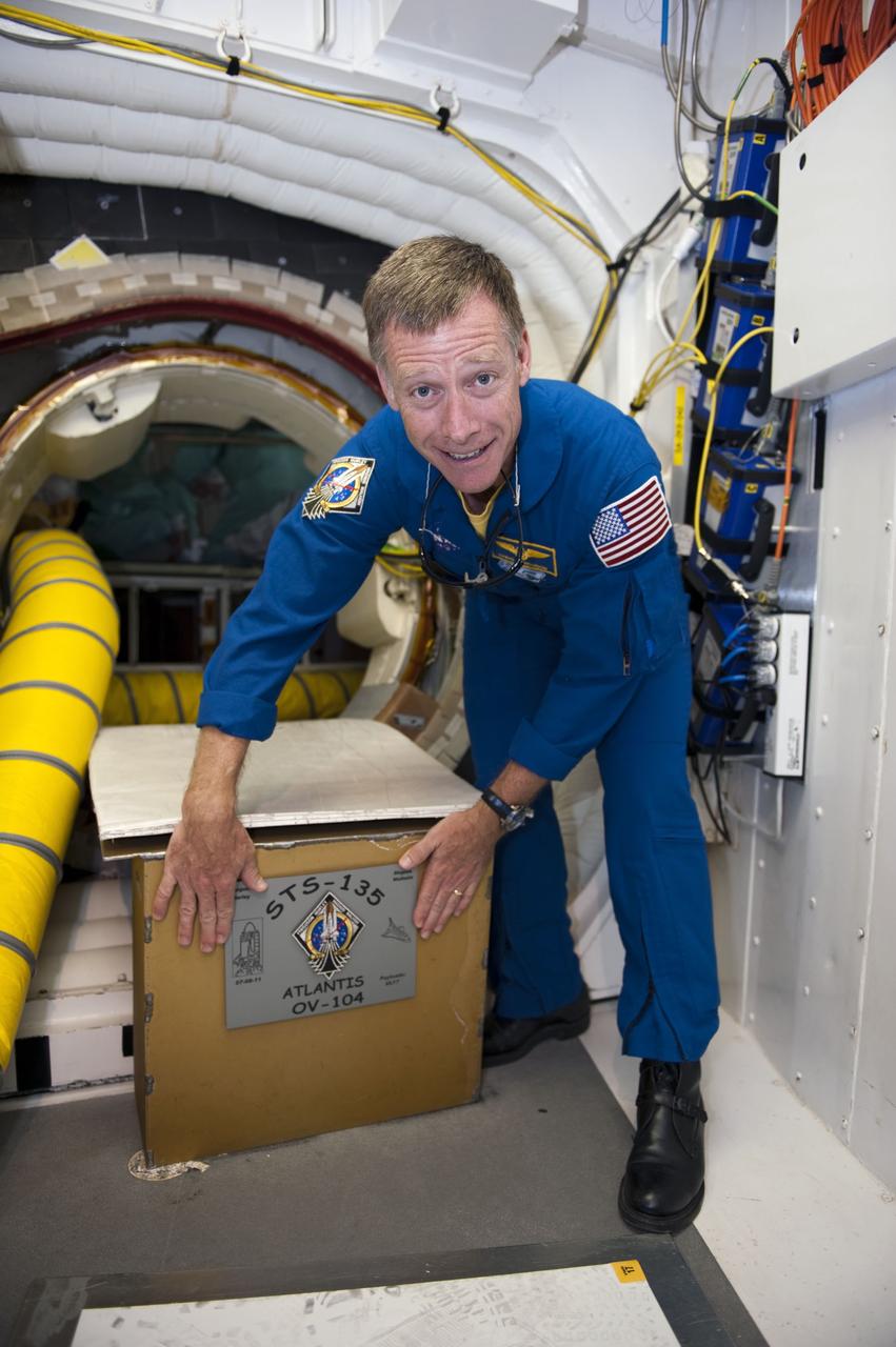 CAPE CANAVERAL, Fla. -- STS-135 Commander Chris Ferguson places a plaque in front of space shuttle Atlantis' hatch in the White Room at NASA Kennedy Space Center's Launch Pad 39A. An access arm supports the White Room that is in place against the shuttle which provides entry to the crew compartment.            The astronauts are at Kennedy to participate in a launch countdown dress rehearsal called the Terminal Countdown Demonstration Test (TCDT) and related training. Atlantis and its crew are targeted to lift off July 8, taking with them the Raffaello multi-purpose logistics module packed with supplies and spare parts to the International Space Station. The STS-135 mission also will fly a system to investigate the potential for robotically refueling existing satellites and return a failed ammonia pump module to help NASA better understand the failure mechanism and improve pump designs for future systems. STS-135 will be the 33rd flight of Atlantis, the 37th shuttle mission to the space station, and the 135th and final mission of NASA's Space Shuttle Program. For more information visit, www.nasa.gov/mission_pages/shuttle/shuttlemissions/sts135/index.html. Photo credit: NASA/Kim Shiflett
