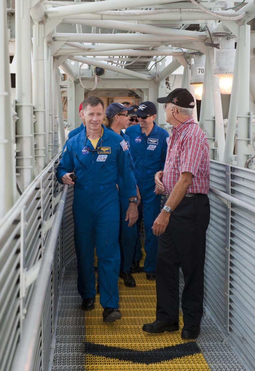 CAPE CANAVERAL, Fla. -- At Launch Pad 39A at NASA's Kennedy Space Center in Florida, the STS-135 crew walk along the White Room's access arm. From left are Commander Chris Ferguson, Pilot Doug Hurley (obstructed), Mission Specialists Sandy Magnus and Rex Walheim. The access arm supports the White Room that is in place against the shuttle which provides entry to the crew compartment. The astronauts are at Kennedy to participate in a launch countdown dress rehearsal called the Terminal Countdown Demonstration Test (TCDT) and related training. Atlantis and its crew are targeted to lift off July 8, taking with them the Raffaello multi-purpose logistics module packed with supplies and spare parts to the International Space Station. The STS-135 mission also will fly a system to investigate the potential for robotically refueling existing satellites and return a failed ammonia pump module to help NASA better understand the failure mechanism and improve pump designs for future systems. STS-135 will be the 33rd flight of Atlantis, the 37th shuttle mission to the space station, and the 135th and final mission of NASA's Space Shuttle Program. For more information visit, www.nasa.gov/mission_pages/shuttle/shuttlemissions/sts135/index.html. Photo credit: NASA/Kim Shiflett