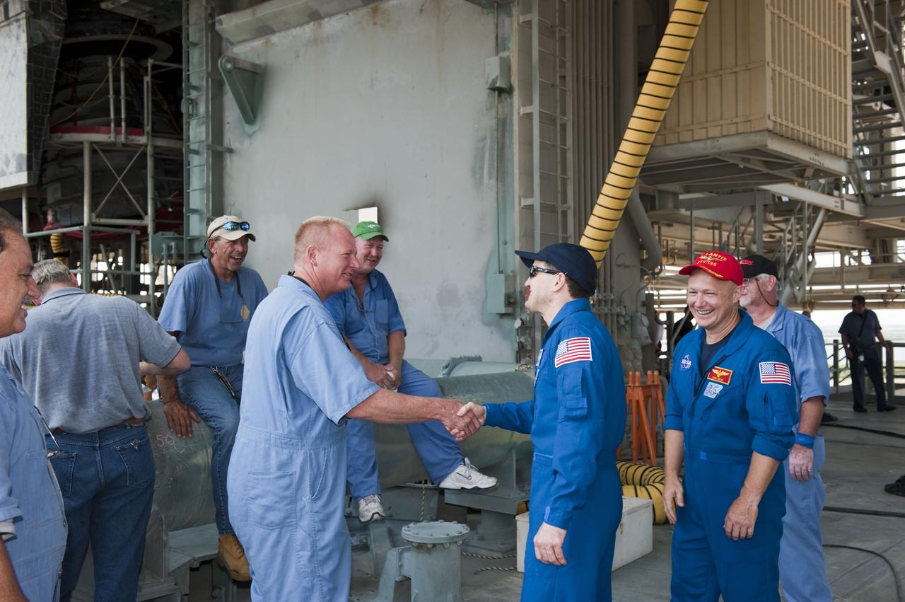 CAPE CANAVERAL, Fla. -- On Launch Pad 39A at NASA's Kennedy Space Center in Florida, space shuttle Atlantis' STS-135 crew members, Mission Specialist Rex Walheim and Pilot Doug Hurley greet the pad workers.      The astronauts are at Kennedy to participate in a launch countdown dress rehearsal called the Terminal Countdown Demonstration Test (TCDT) and related training. Atlantis and its crew are targeted to lift off July 8, taking with them the Raffaello multi-purpose logistics module packed with supplies and spare parts to the International Space Station. The STS-135 mission also will fly a system to investigate the potential for robotically refueling existing satellites and return a failed ammonia pump module to help NASA better understand the failure mechanism and improve pump designs for future systems. STS-135 will be the 33rd flight of Atlantis, the 37th shuttle mission to the space station, and the 135th and final mission of NASA's Space Shuttle Program. For more information visit, www.nasa.gov/mission_pages/shuttle/shuttlemissions/sts135/index.html. Photo credit: NASA/Kim Shiflett