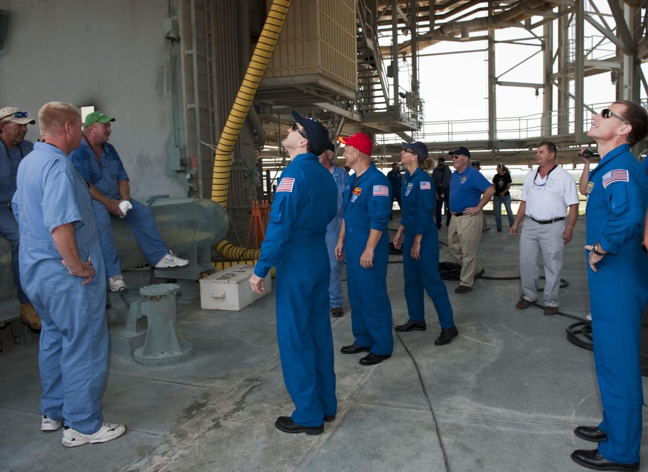 CAPE CANAVERAL, Fla. -- On Launch Pad 39A at NASA's Kennedy Space Center in Florida, space shuttle Atlantis' STS-135 crew members, become familiar with the pad structure as part of their emergency exit training. Seen here are Mission Specialist Rex Walheim (center), Pilot Doug Hurley, Mission Specialist Sandy Magnus and Commander Chris Ferguson (far right).        The astronauts are at Kennedy to participate in a launch countdown dress rehearsal called the Terminal Countdown Demonstration Test (TCDT) and related training. Atlantis and its crew are targeted to lift off July 8, taking with them the Raffaello multi-purpose logistics module packed with supplies and spare parts to the International Space Station. The STS-135 mission also will fly a system to investigate the potential for robotically refueling existing satellites and return a failed ammonia pump module to help NASA better understand the failure mechanism and improve pump designs for future systems. STS-135 will be the 33rd flight of Atlantis, the 37th shuttle mission to the space station, and the 135th and final mission of NASA's Space Shuttle Program. For more information visit, www.nasa.gov/mission_pages/shuttle/shuttlemissions/sts135/index.html. Photo credit: NASA/Kim Shiflett