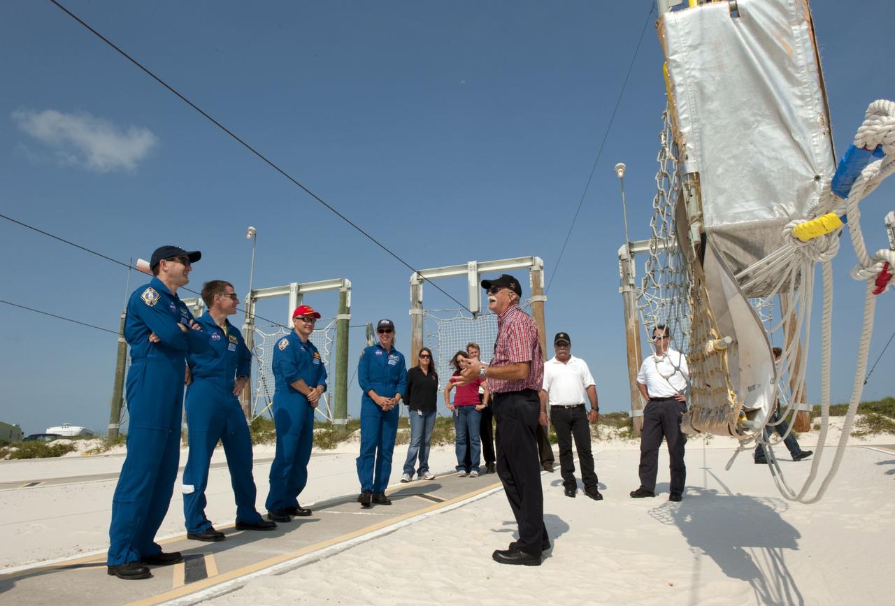CAPE CANAVERAL, Fla. -- At Launch Pad 39A at NASA's Kennedy Space Center in Florida, members of space shuttle Atlantis' STS-135 crew receive instruction by the catch nets for the slidewire baskets at the base of the pad as part of the pad's emergency exit training. From left are Mission Specialist Rex Walheim, Commander Chris Ferguson, Pilot Doug Hurley and Mission Specialist Sandy Magnus.          The astronauts are at Kennedy to participate in a launch countdown dress rehearsal called the Terminal Countdown Demonstration Test (TCDT) and related training. Atlantis and its crew are targeted to lift off July 8, taking with them the Raffaello multi-purpose logistics module packed with supplies and spare parts to the International Space Station. The STS-135 mission also will fly a system to investigate the potential for robotically refueling existing satellites and return a failed ammonia pump module to help NASA better understand the failure mechanism and improve pump designs for future systems. STS-135 will be the 33rd flight of Atlantis, the 37th shuttle mission to the space station, and the 135th and final mission of NASA's Space Shuttle Program. For more information visit, www.nasa.gov/mission_pages/shuttle/shuttlemissions/sts135/index.html. Photo credit: NASA/Kim Shiflett