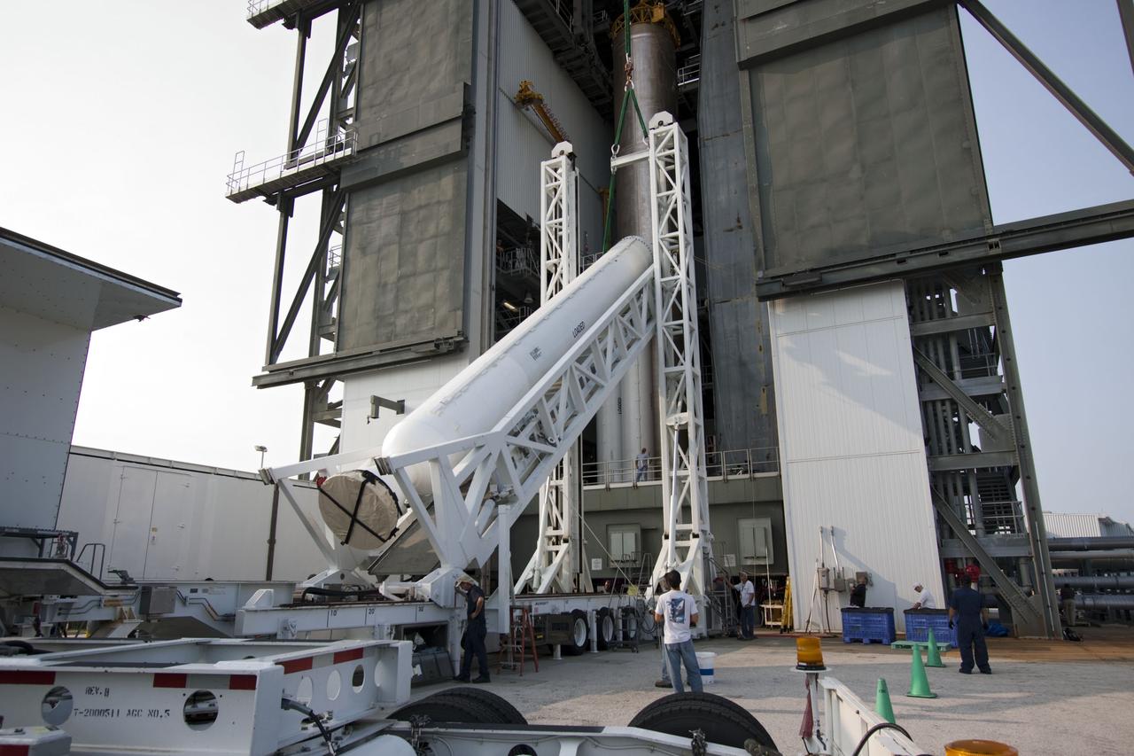 CAPE CANAVERAL, Fla. -- At Cape Canaveral Air Force Station in Florida, workers using an overhead crane lift the fifth and final solid rocket booster into the Vertical Integration Facility at Launch Complex 41. It then will be attached to the United Launch Alliance Atlas V booster stage, already at the pad.            NASA's Juno spacecraft is scheduled to launch aboard an Atlas V from Cape Canaveral, Fla. Aug. 5.The solar-powered spacecraft will orbit Jupiter's poles 33 times to find out more about the gas giant's origins, structure, atmosphere and magnetosphere and investigate the existence of a solid planetary core. For more information visit: www.nasa.gov/juno. Photo credit: NASA/Jim Grossmann