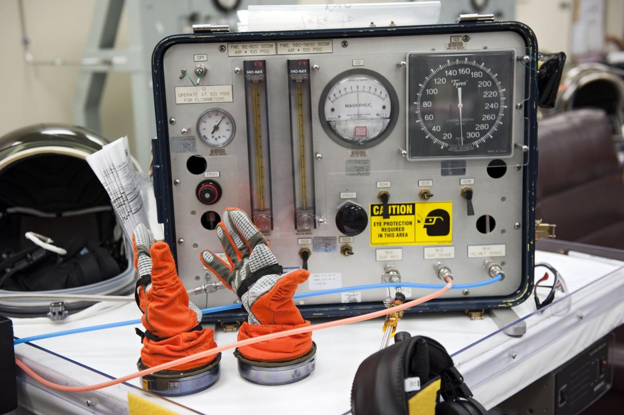 CAPE CANAVERAL, Fla. -- In the Operations and Checkout Building at NASA's Kennedy Space Center in Florida, the astronauts of space shuttle Atlantis' STS-135 crew put on their launch-and-entry suits and check the fit of their helmets and gloves. Seen here is a unit that checks air pressure flowing through the suits to ensure there are no leaks.              As part of the Terminal Countdown Demonstration Test (TCDT), the crew members are taken to Kennedy's Launch Pad 39A and strapped into space shuttle Atlantis to practice the steps that will be taken on launch day. Atlantis and its crew are targeted to lift off July 8, taking with them the Raffaello multi-purpose logistics module packed with supplies and spare parts to the International Space Station. The STS-135 mission also will fly a system to investigate the potential for robotically refueling existing satellites and return a failed ammonia pump module to help NASA better understand the failure mechanism and improve pump designs for future systems. STS-135 will be the 33rd flight of Atlantis, the 37th shuttle mission to the space station, and the 135th and final mission of NASA's Space Shuttle Program. For more information visit, www.nasa.gov/mission_pages/shuttle/shuttlemissions/sts135/index.html. Photo credit: NASA/Kim Shiflett