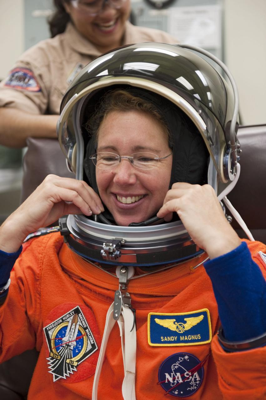 CAPE CANAVERAL, Fla. -- In the Operations and Checkout Building at NASA's Kennedy Space Center in Florida, STS-135 Mission Specialist Sandy Magnus checks the fit of her launch-and-entry suit and helmet during a simulated launch countdown.           As part of the Terminal Countdown Demonstration Test (TCDT), the crew members are taken to Kennedy's Launch Pad 39A and strapped into space shuttle Atlantis to practice the steps that will be taken on launch day. Atlantis and its crew are targeted to lift off July 8, taking with them the Raffaello multi-purpose logistics module packed with supplies and spare parts to the International Space Station. The STS-135 mission also will fly a system to investigate the potential for robotically refueling existing satellites and return a failed ammonia pump module to help NASA better understand the failure mechanism and improve pump designs for future systems. STS-135 will be the 33rd flight of Atlantis, the 37th shuttle mission to the space station, and the 135th and final mission of NASA's Space Shuttle Program. For more information visit, www.nasa.gov/mission_pages/shuttle/shuttlemissions/sts135/index.html. Photo credit: NASA/Kim Shiflett
