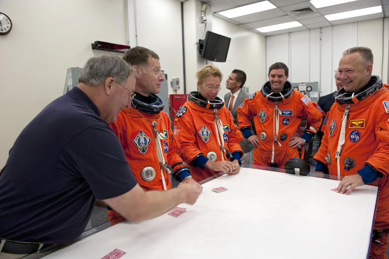 CAPE CANAVERAL, Fla. -- In the Operations and Checkout Building at NASA's Kennedy Space Center in Florida, the STS-135 crew members enjoy a light moment during a simulated launch countdown. From left are Jerry Ross, chief of the Vehicle Integration Test Office and former NASA astronaut, Commander Chris Ferguson, Mission Specialists Sandy Magnus and Rex Walheim, and Pilot Doug Hurley.      As part of the Terminal Countdown Demonstration Test (TCDT), the crew members are taken to Kennedy's Launch Pad 39A and strapped into space shuttle Atlantis to practice the steps that will be taken on launch day. Atlantis and its crew are targeted to lift off July 8, taking with them the Raffaello multi-purpose logistics module packed with supplies and spare parts to the International Space Station. The STS-135 mission also will fly a system to investigate the potential for robotically refueling existing satellites and return a failed ammonia pump module to help NASA better understand the failure mechanism and improve pump designs for future systems. STS-135 will be the 33rd flight of Atlantis, the 37th shuttle mission to the space station, and the 135th and final mission of NASA's Space Shuttle Program. For more information visit, www.nasa.gov/mission_pages/shuttle/shuttlemissions/sts135/index.html. Photo credit: NASA/Kim Shiflett