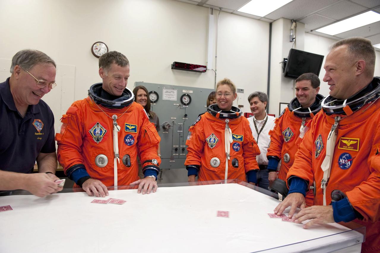 CAPE CANAVERAL, Fla. -- In the Operations and Checkout Building at NASA's Kennedy Space Center in Florida, the STS-135 crew members enjoy a light moment during a simulated launch countdown. From left are Jerry Ross, chief of the Vehicle Integration Test Office and former NASA astronaut, Commander Chris Ferguson, Mission Specialists Sandy Magnus and Rex Walheim, and Pilot Doug Hurley.      As part of the Terminal Countdown Demonstration Test (TCDT), the crew members are taken to Kennedy's Launch Pad 39A and strapped into space shuttle Atlantis to practice the steps that will be taken on launch day. Atlantis and its crew are targeted to lift off July 8, taking with them the Raffaello multi-purpose logistics module packed with supplies and spare parts to the International Space Station. The STS-135 mission also will fly a system to investigate the potential for robotically refueling existing satellites and return a failed ammonia pump module to help NASA better understand the failure mechanism and improve pump designs for future systems. STS-135 will be the 33rd flight of Atlantis, the 37th shuttle mission to the space station, and the 135th and final mission of NASA's Space Shuttle Program. For more information visit, www.nasa.gov/mission_pages/shuttle/shuttlemissions/sts135/index.html. Photo credit: NASA/Kim Shiflett