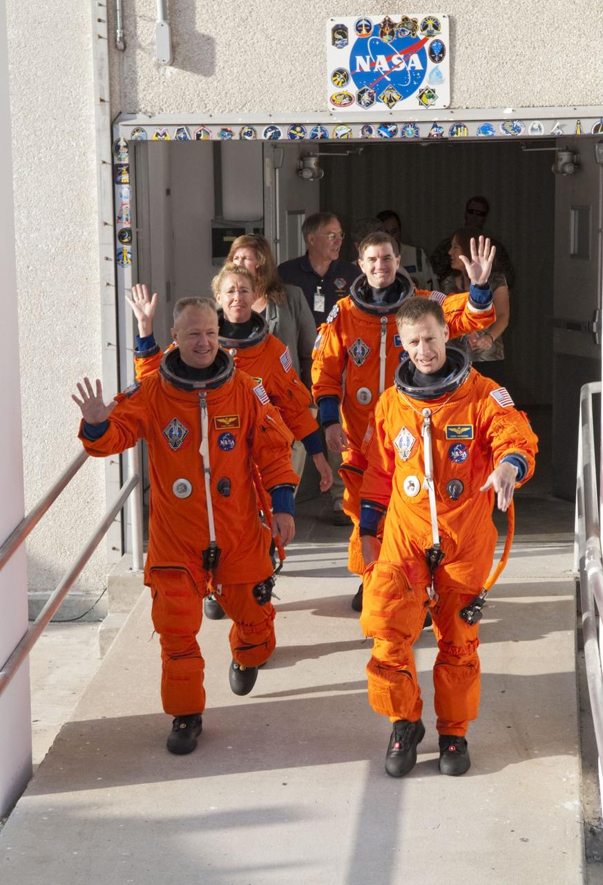CAPE CANAVERAL, Fla. -- During a simulated launch countdown, the STS-135 crew walks out of the Operations and Checkout Building to the waiting Astrovan at NASA's Kennedy Space Center in Florida. As part of the Terminal Countdown Demonstration Test (TCDT), the crew members are driven to Kennedy's Launch Pad 39A and then are strapped into space shuttle Atlantis to practice the steps that will be taken on launch day. On the front row are STS-135 Pilot Doug Hurley (left) and Commander Chris Ferguson; second row; are Mission Specialists Sandy Magnus and Rex Walheim.         Atlantis and its crew are targeted to lift off July 8, taking with them the Raffaello multi-purpose logistics module packed with supplies and spare parts to the International Space Station. The STS-135 mission also will fly a system to investigate the potential for robotically refueling existing satellites and return a failed ammonia pump module to help NASA better understand the failure mechanism and improve pump designs for future systems. STS-135 will be the 33rd flight of Atlantis, the 37th shuttle mission to the space station, and the 135th and final mission of NASA's Space Shuttle Program. For more information visit, www.nasa.gov/mission_pages/shuttle/shuttlemissions/sts135/index.html. Photo credit: NASA/Kim Shiflett