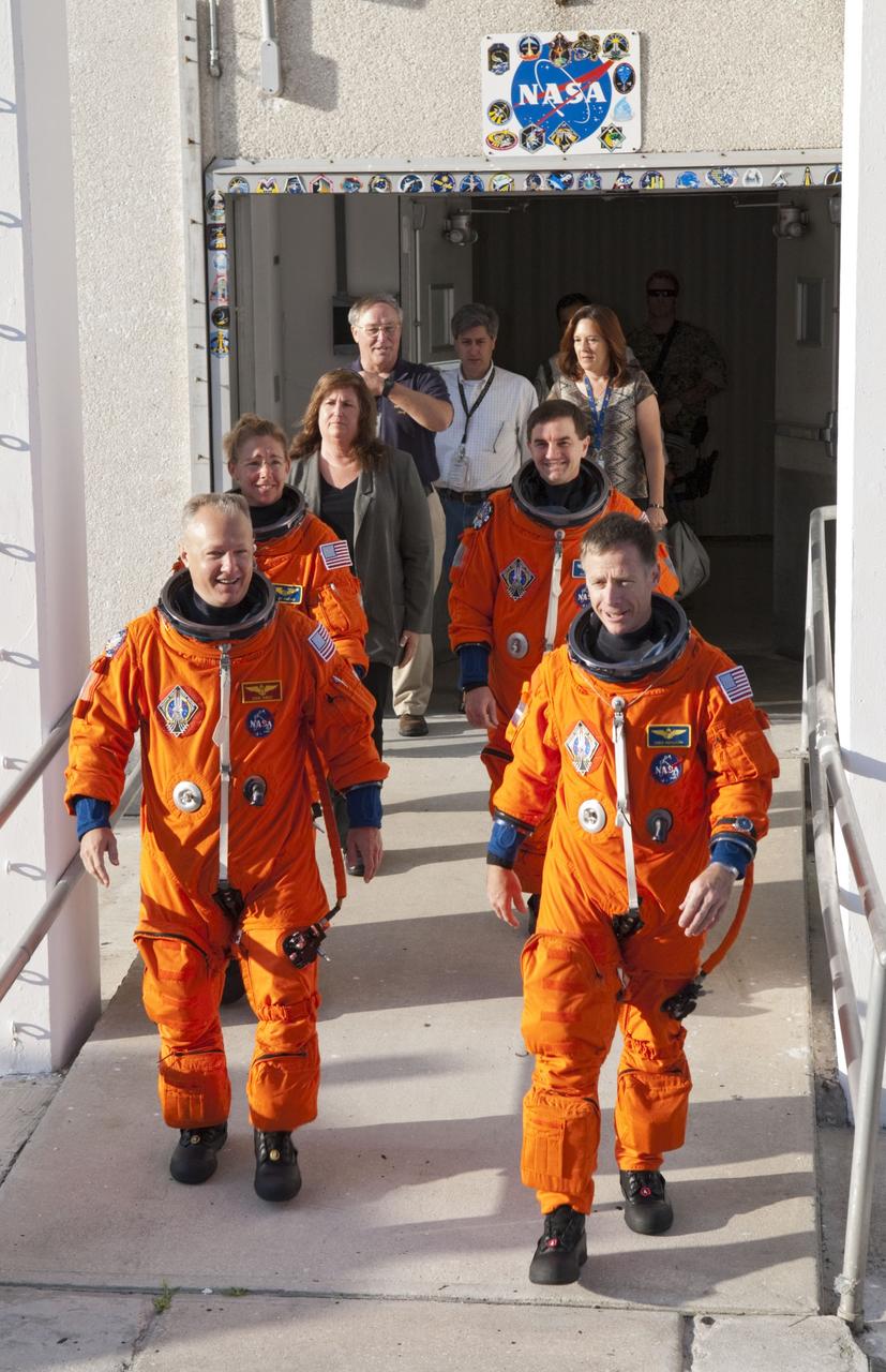 CAPE CANAVERAL, Fla. -- During a simulated launch countdown, the STS-135 crew walks out of the Operations and Checkout Building to the waiting Astrovan at NASA's Kennedy Space Center in Florida. As part of the Terminal Countdown Demonstration Test (TCDT), the crew members are driven to Kennedy's Launch Pad 39A and then are strapped into space shuttle Atlantis to practice the steps that will be taken on launch day. On the front row are STS-135 Pilot Doug Hurley (left) and Commander Chris Ferguson; second row; are Mission Specialists Sandy Magnus and Rex Walheim.       Atlantis and its crew are targeted to lift off July 8, taking with them the Raffaello multi-purpose logistics module packed with supplies and spare parts to the International Space Station. The STS-135 mission also will fly a system to investigate the potential for robotically refueling existing satellites and return a failed ammonia pump module to help NASA better understand the failure mechanism and improve pump designs for future systems. STS-135 will be the 33rd flight of Atlantis, the 37th shuttle mission to the space station, and the 135th and final mission of NASA's Space Shuttle Program. For more information visit, www.nasa.gov/mission_pages/shuttle/shuttlemissions/sts135/index.html. Photo credit: NASA/Kim Shiflett