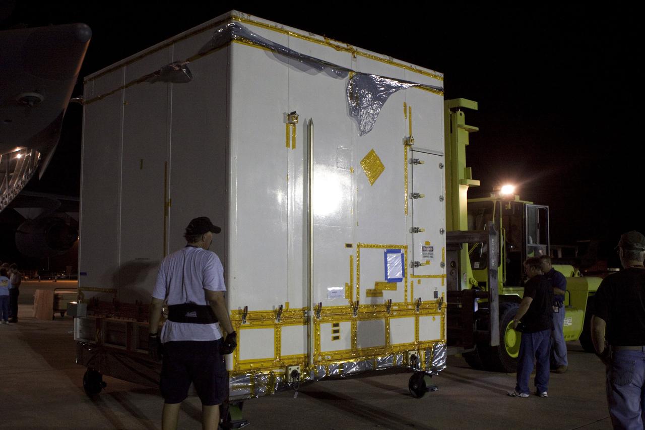 CAPE CANAVERAL, Fla. -- Workers load a container holding NASA's Mars Science Laboratory (MSL) rocket-powered descent stage that will fly the rover during the final moments before landing on Mars, onto a transporter after arrival at NASA Kennedy Space Center's Shuttle Landing Facility in Florida. The MSL rover known as Curiosity is also aboard the Air Force C-17 cargo plane ready for unloading. A United Launch Alliance Atlas V-541 configuration will be used to loft MSL into space. Curiosity’s 10 science instruments are designed to search for evidence on whether Mars has had environments favorable to microbial life, including chemical ingredients for life. The unique rover will use a laser to look inside rocks and release its gasses so that the rover’s spectrometer can analyze and send the data back to Earth. MSL is scheduled to launch from Cape Canaveral Air Force Station in Florida Nov. 25 with a window extending to Dec. 18 and arrival at Mars Aug. 2012. For more information, visit http://www.nasa.gov/msl. Photo credit: NASA/Troy Cryder