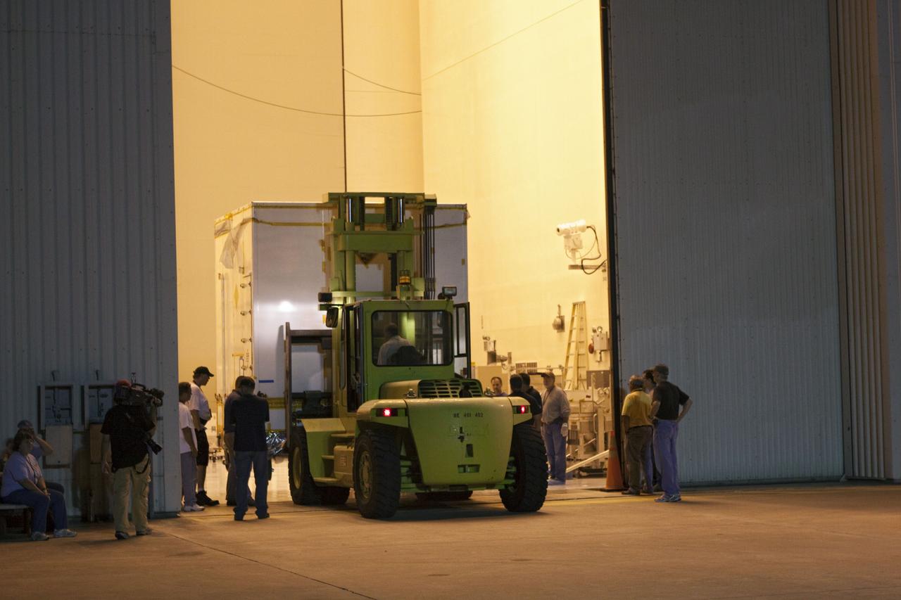 CAPE CANAVERAL, Fla. -- Workers deliver a container holding NASA's Mars Science Laboratory (MSL) rocket-powered descent stage that will fly the rover during the final moments before landing on Mars, to the Payload Hazardous Servicing Facility (PHSF) at NASA Kennedy Space Center in Florida. A United Launch Alliance Atlas V-541 configuration will be used to loft MSL into space. Curiosity’s 10 science instruments are designed to search for evidence on whether Mars has had environments favorable to microbial life, including chemical ingredients for life. The unique rover will use a laser to look inside rocks and release its gasses so that the rover’s spectrometer can analyze and send the data back to Earth. MSL is scheduled to launch from Cape Canaveral Air Force Station in Florida Nov. 25 with a window extending to Dec. 18 and arrival at Mars Aug. 2012. For more information, visit http://www.nasa.gov/msl. Photo credit: NASA/Troy Cryder