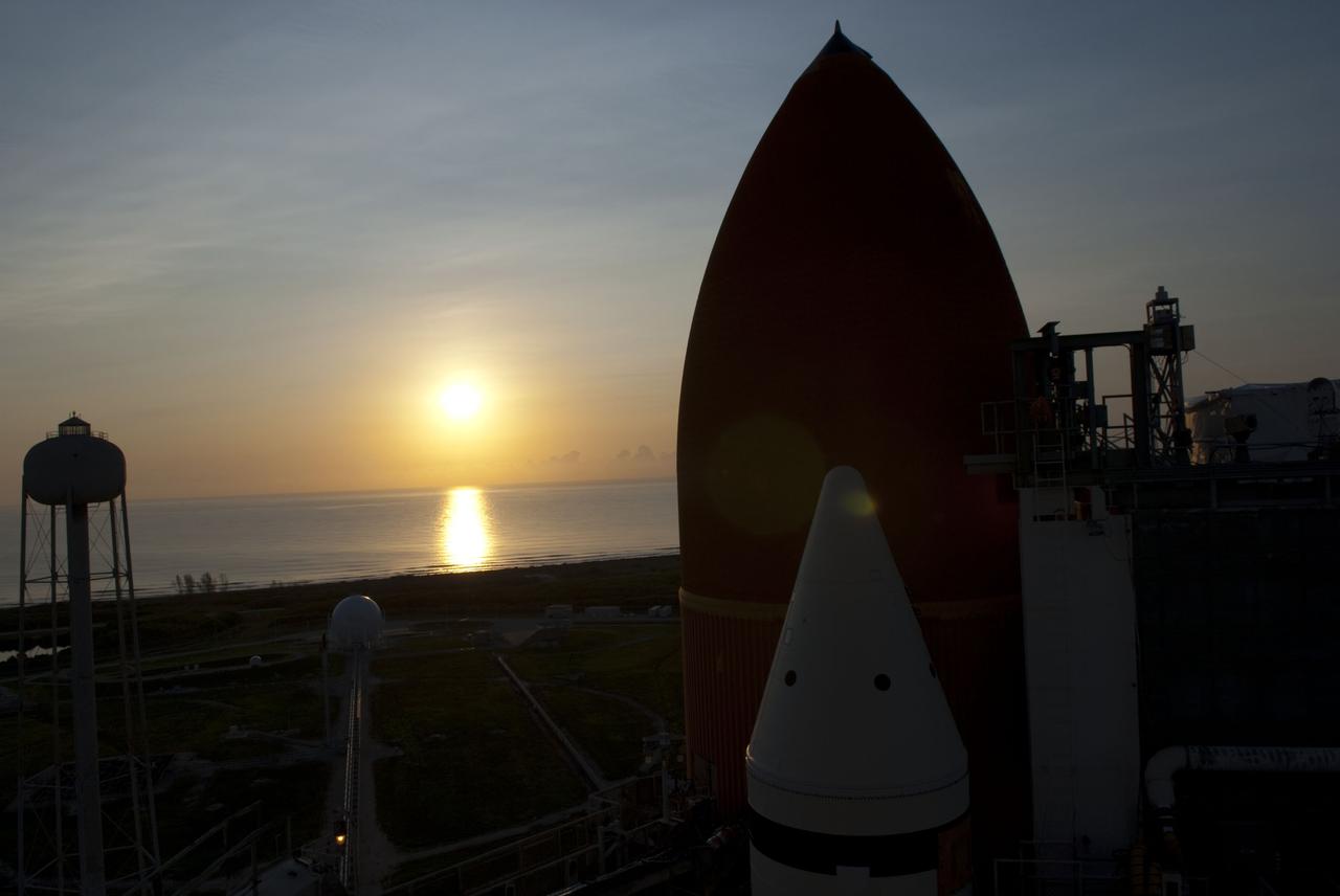 CAPE CANAVERAL, Fla. -- The sun rises over the Atlantic Ocean silhouetting space shuttle Atlantis' external fuel tank and solid rocket boosters on Launch Pad 39A at NASA's Kennedy Space Center in Florida. The STS-135 crew members will be at the pad to participate in a launch countdown simulation exercise.              As part of the Terminal Countdown Demonstration Test (TCDT), the crew members are strapped into their seats on Atlantis to practice the steps that will be taken on launch day. Shuttle Atlantis and its crew are targeted to lift off July 8, taking with them the Raffaello multi-purpose logistics module packed with supplies and spare parts to the International Space Station. The STS-135 mission also will fly a system to investigate the potential for robotically refueling existing satellites and return a failed ammonia pump module to help NASA better understand the failure mechanism and improve pump designs for future systems. STS-135 will be the 33rd flight of Atlantis, the 37th shuttle mission to the space station, and the 135th and final mission of NASA's Space Shuttle Program. For more information visit, www.nasa.gov/mission_pages/shuttle/shuttlemissions/sts135/index.html. Photo credit: NASA/Jim Grossmann