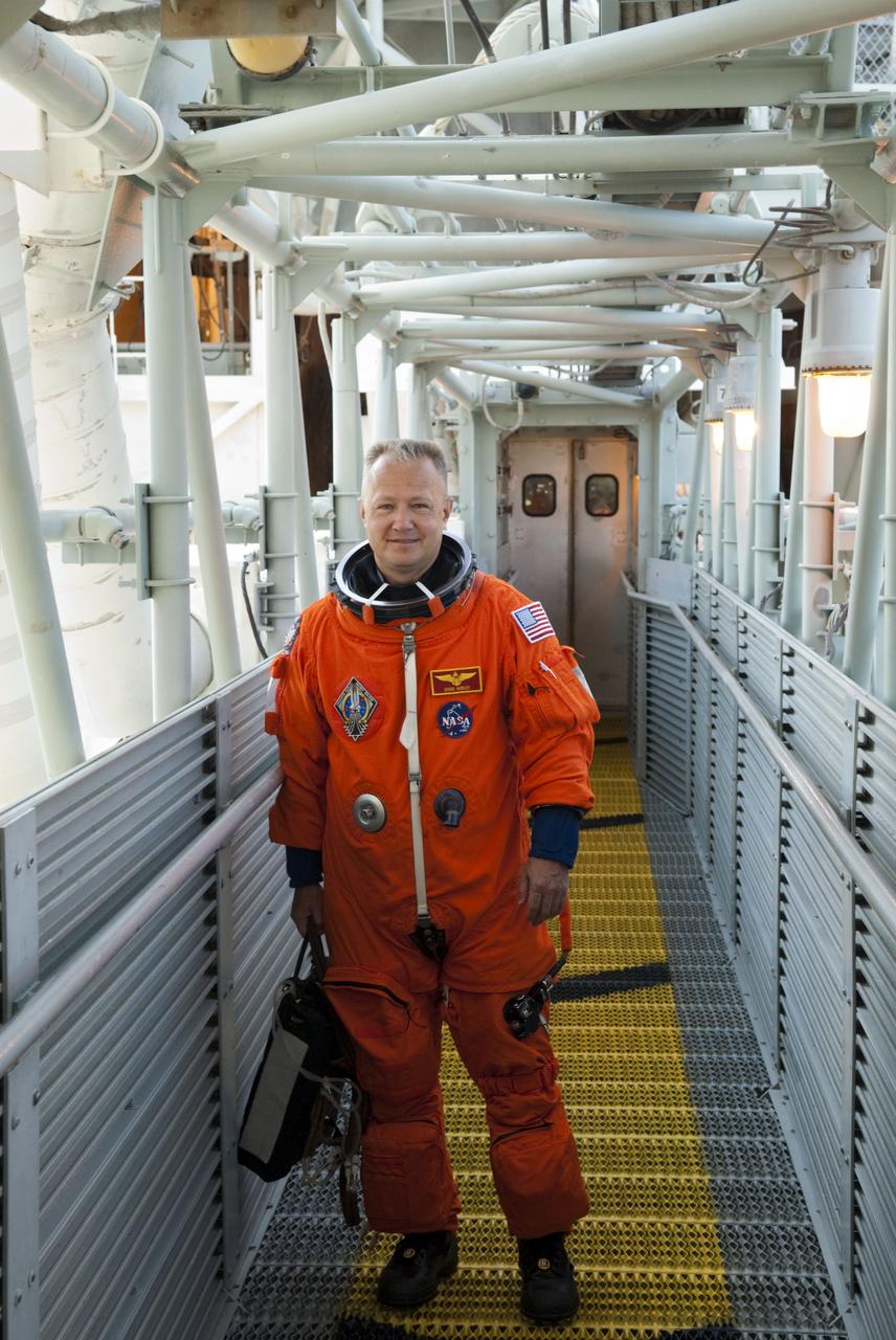 CAPE CANAVERAL, Fla. -- STS-135 Pilot Doug Hurley stands on the walkway to the White Room which provides entry to space shuttle Atlantis' crew compartment on Launch Pad 39A at NASA's Kennedy Space Center in Florida. Atlantis' crew members are at the pad to participate in a launch countdown simulation exercise.      As part of the Terminal Countdown Demonstration Test (TCDT), the crew members are strapped into their seats on Atlantis to practice the steps that will be taken on launch day. Shuttle Atlantis and its crew are targeted to lift off July 8, taking with them the Raffaello multi-purpose logistics module packed with supplies and spare parts to the International Space Station. The STS-135 mission also will fly a system to investigate the potential for robotically refueling existing satellites and return a failed ammonia pump module to help NASA better understand the failure mechanism and improve pump designs for future systems. STS-135 will be the 33rd flight of Atlantis, the 37th shuttle mission to the space station, and the 135th and final mission of NASA's Space Shuttle Program. For more information visit, www.nasa.gov/mission_pages/shuttle/shuttlemissions/sts135/index.html. Photo credit: NASA/Jim Grossmann