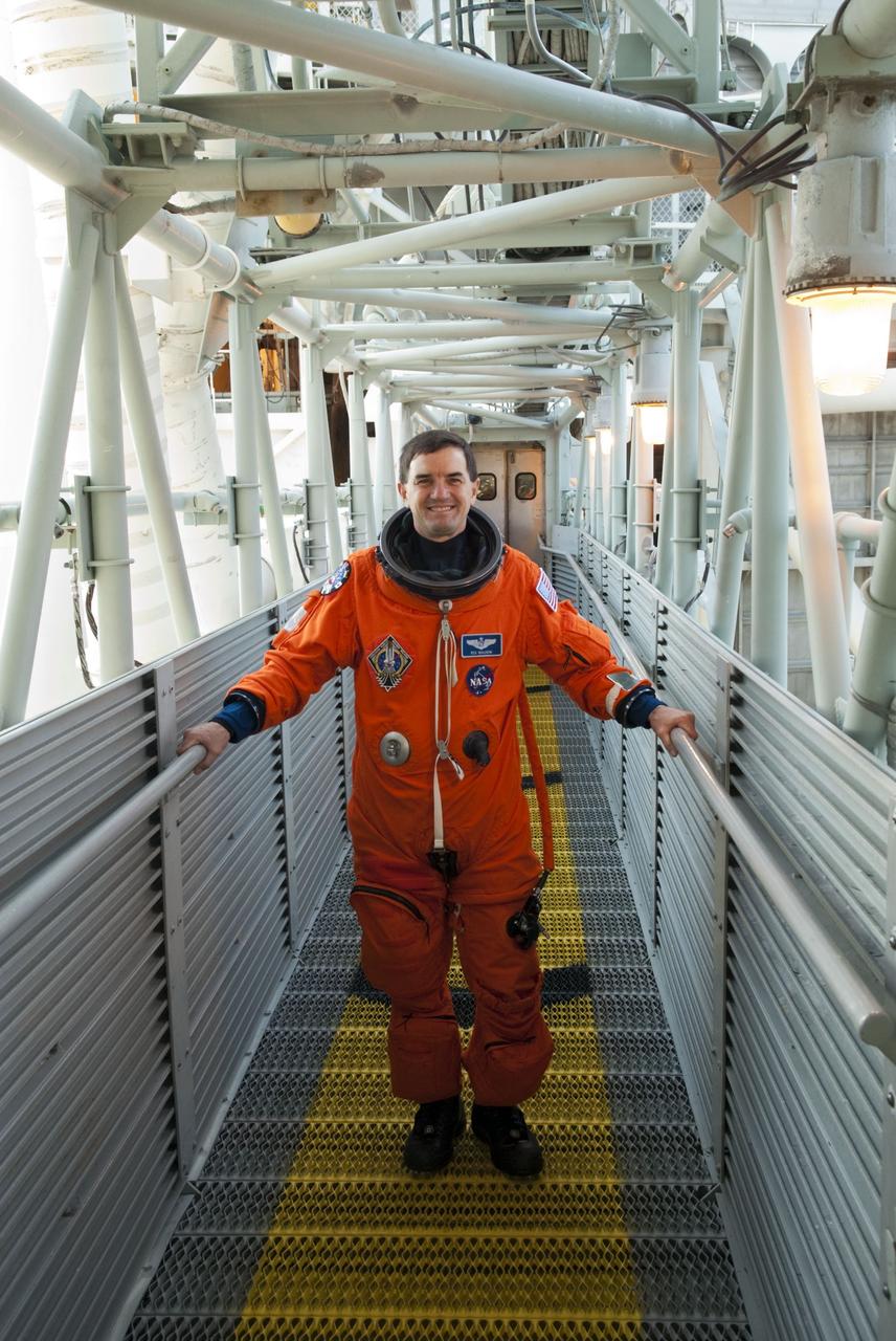 CAPE CANAVERAL, Fla. -- STS-135 Mission Specialist Rex Walheim stands on the walkway to the White Room which provides entry to space shuttle Atlantis' crew compartment on Launch Pad 39A at NASA's Kennedy Space Center in Florida. Atlantis' crew members are at the pad to participate in a launch countdown simulation exercise.      As part of the Terminal Countdown Demonstration Test (TCDT), the crew members are strapped into their seats on Atlantis to practice the steps that will be taken on launch day. Shuttle Atlantis and its crew are targeted to lift off July 8, taking with them the Raffaello multi-purpose logistics module packed with supplies and spare parts to the International Space Station. The STS-135 mission also will fly a system to investigate the potential for robotically refueling existing satellites and return a failed ammonia pump module to help NASA better understand the failure mechanism and improve pump designs for future systems. STS-135 will be the 33rd flight of Atlantis, the 37th shuttle mission to the space station, and the 135th and final mission of NASA's Space Shuttle Program. For more information visit, www.nasa.gov/mission_pages/shuttle/shuttlemissions/sts135/index.html. Photo credit: NASA/Jim Grossmann