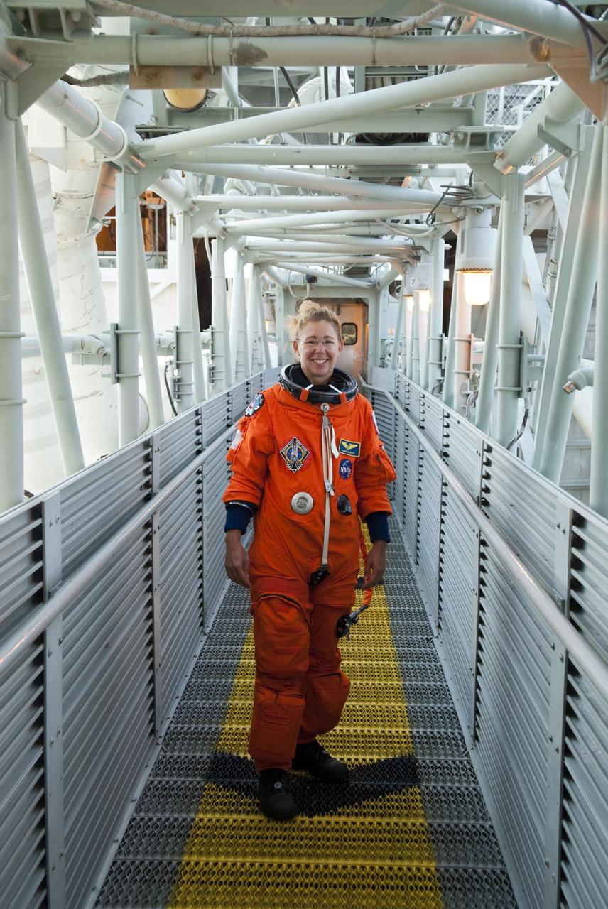 CAPE CANAVERAL, Fla. -- STS-135 Mission Specialist Sandy Magnus stands on the walkway to the White Room which provides entry to space shuttle Atlantis' crew compartment on Launch Pad 39A at NASA's Kennedy Space Center in Florida. Atlantis' crew members are at the pad to participate in a launch countdown simulation exercise.      As part of the Terminal Countdown Demonstration Test (TCDT), the crew members are strapped into their seats on Atlantis to practice the steps that will be taken on launch day. Shuttle Atlantis and its crew are targeted to lift off July 8, taking with them the Raffaello multi-purpose logistics module packed with supplies and spare parts to the International Space Station. The STS-135 mission also will fly a system to investigate the potential for robotically refueling existing satellites and return a failed ammonia pump module to help NASA better understand the failure mechanism and improve pump designs for future systems. STS-135 will be the 33rd flight of Atlantis, the 37th shuttle mission to the space station, and the 135th and final mission of NASA's Space Shuttle Program. For more information visit, www.nasa.gov/mission_pages/shuttle/shuttlemissions/sts135/index.html. Photo credit: NASA/Jim Grossmann
