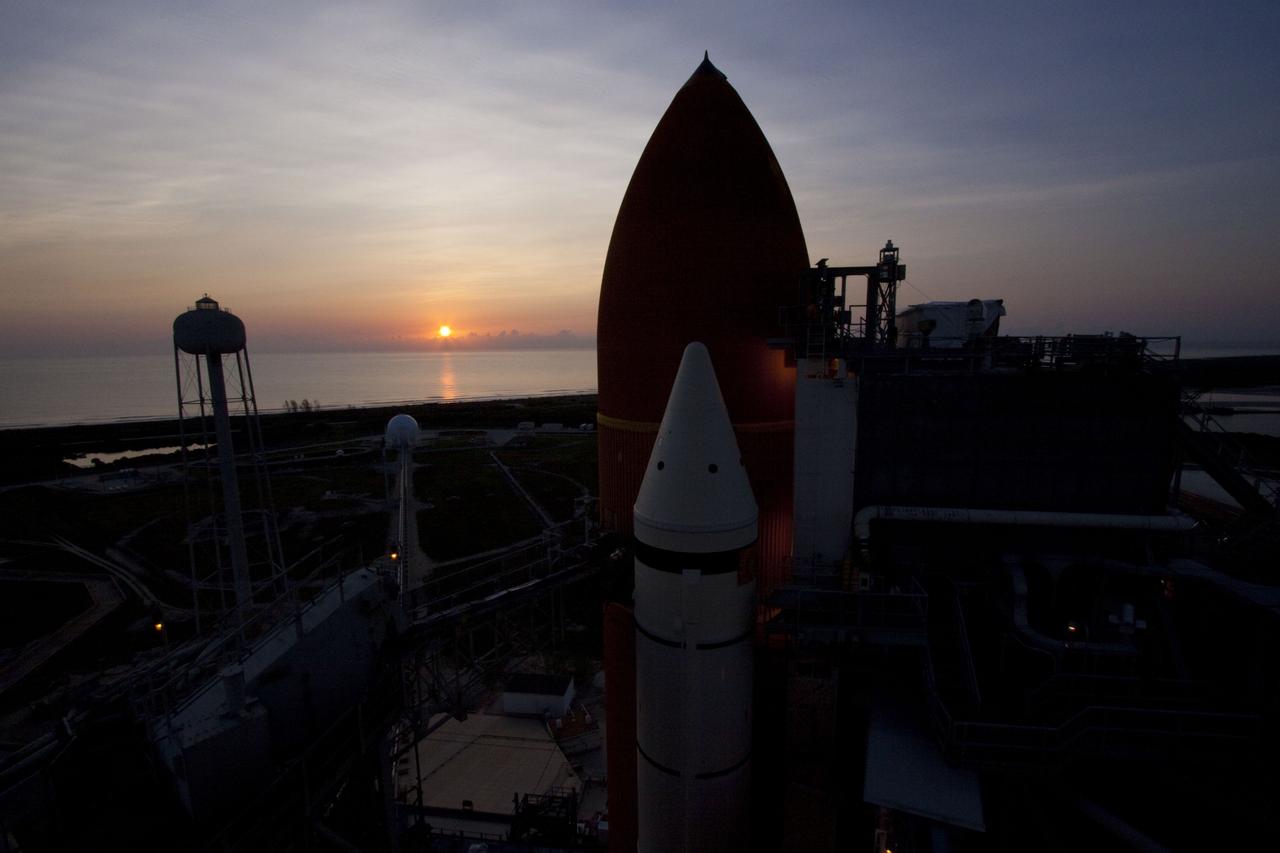 CAPE CANAVERAL, Fla. -- The sun rises over the Atlantic Ocean silhouetting space shuttle Atlantis' external fuel tank and solid rocket boosters on Launch Pad 39A at NASA's Kennedy Space Center in Florida. The STS-135 crew members will be at the pad to participate in a launch countdown simulation exercise.    As part of the Terminal Countdown Demonstration Test (TCDT), the crew members are strapped into their seats on Atlantis to practice the steps that will be taken on launch day. Shuttle Atlantis and its crew are targeted to lift off July 8, taking with them the Raffaello multi-purpose logistics module packed with supplies and spare parts to the International Space Station. The STS-135 mission also will fly a system to investigate the potential for robotically refueling existing satellites and return a failed ammonia pump module to help NASA better understand the failure mechanism and improve pump designs for future systems. STS-135 will be the 33rd flight of Atlantis, the 37th shuttle mission to the space station, and the 135th and final mission of NASA's Space Shuttle Program. For more information visit, www.nasa.gov/mission_pages/shuttle/shuttlemissions/sts135/index.html. Photo credit: NASA/Jim Grossmann