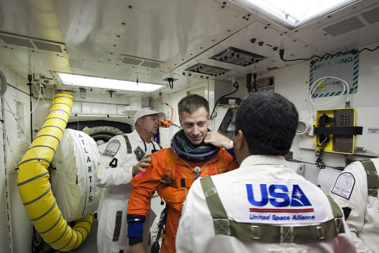 CAPE CANAVERAL, Fla. -- In the White Room at Launch Pad 39A at NASA's Kennedy Space Center in Florida, STS-135 Commander Chris Ferguson prepares to board space shuttle Atlantis through the crew hatch in the background. Members of the Closeout Crew, in white uniforms, are there to assist astronauts with their launch-and-entry suits and the boarding process. The STS-135 crew members are at the pad to participate in a launch countdown simulation exercise.      As part of the Terminal Countdown Demonstration Test (TCDT), the crew members are strapped into their seats on Atlantis to practice the steps that will be taken on launch day. Shuttle Atlantis and its crew are targeted to lift off July 8, taking with them the Raffaello multi-purpose logistics module packed with supplies and spare parts to the International Space Station. The STS-135 mission also will fly a system to investigate the potential for robotically refueling existing satellites and return a failed ammonia pump module to help NASA better understand the failure mechanism and improve pump designs for future systems. STS-135 will be the 33rd flight of Atlantis, the 37th shuttle mission to the space station, and the 135th and final mission of NASA's Space Shuttle Program. For more information visit, www.nasa.gov/mission_pages/shuttle/shuttlemissions/sts135/index.html. Photo credit: NASA/Jim Grossmann