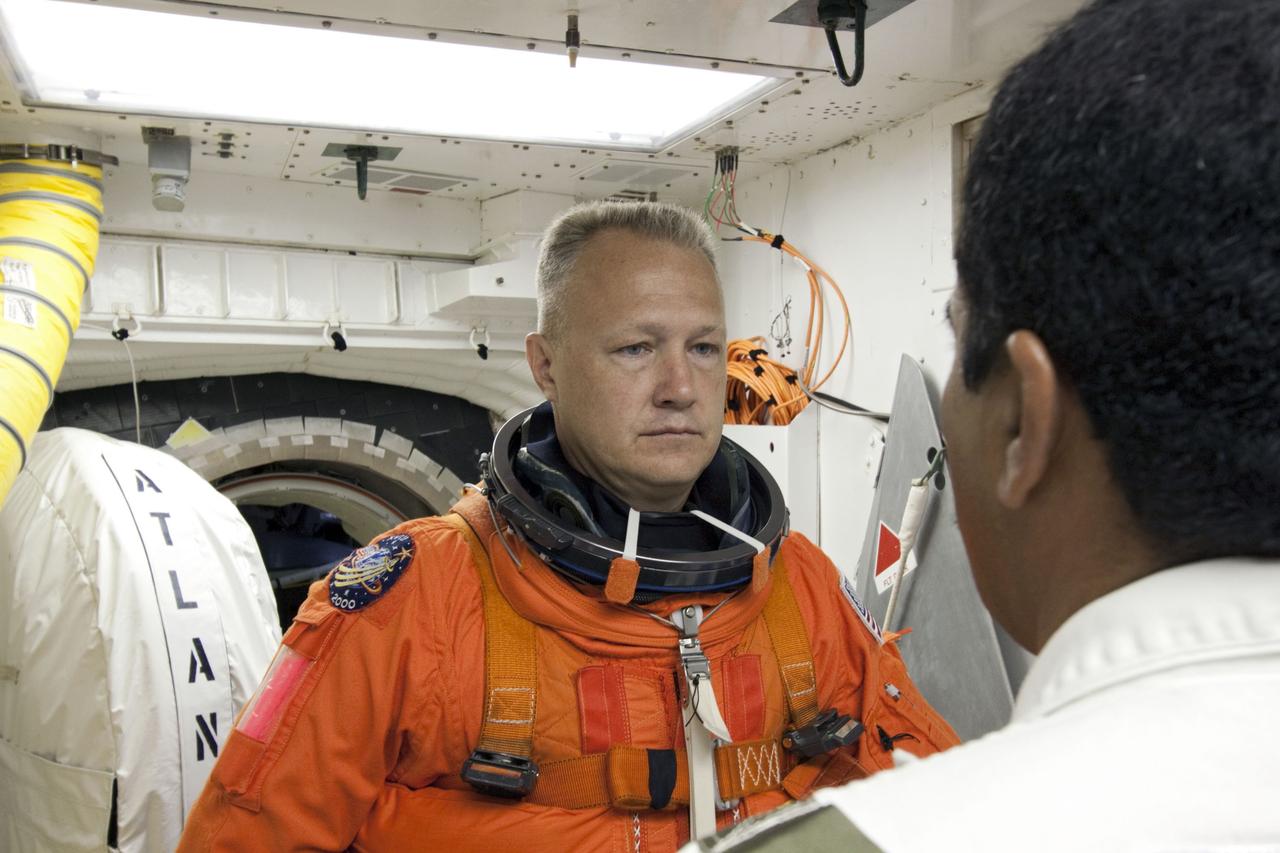 CAPE CANAVERAL, Fla. -- In the White Room at Launch Pad 39A at NASA's Kennedy Space Center in Florida, STS-135 Pilot Doug Hurley prepares to board space shuttle Atlantis through the crew hatch in the background. Members of the Closeout Crew, in white uniforms, are there to assist astronauts with their launch-and-entry suits and the boarding process. The STS-135 crew members are at the pad to participate in a launch countdown simulation exercise.    As part of the Terminal Countdown Demonstration Test (TCDT), the crew members are strapped into their seats on Atlantis to practice the steps that will be taken on launch day. Shuttle Atlantis and its crew are targeted to lift off July 8, taking with them the Raffaello multi-purpose logistics module packed with supplies and spare parts to the International Space Station. The STS-135 mission also will fly a system to investigate the potential for robotically refueling existing satellites and return a failed ammonia pump module to help NASA better understand the failure mechanism and improve pump designs for future systems. STS-135 will be the 33rd flight of Atlantis, the 37th shuttle mission to the space station, and the 135th and final mission of NASA's Space Shuttle Program. For more information visit, www.nasa.gov/mission_pages/shuttle/shuttlemissions/sts135/index.html. Photo credit: NASA/Jim Grossmann