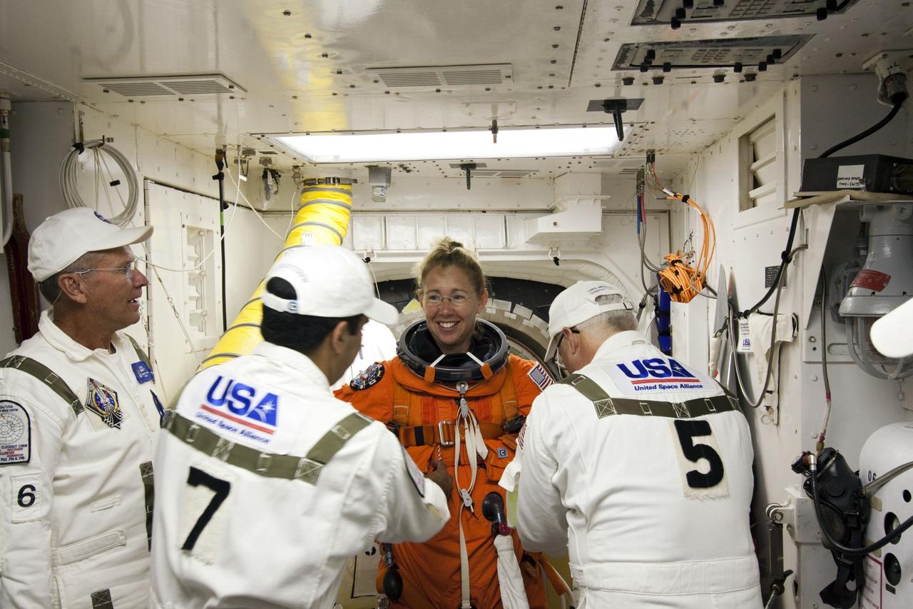 CAPE CANAVERAL, Fla. -- In the White Room at Launch Pad 39A at NASA's Kennedy Space Center in Florida, STS-135 Mission Specialist Sandy Magnus prepares to board space shuttle Atlantis through the crew hatch in the background. Members of the Closeout Crew, in white uniforms, are there to assist astronauts with their launch-and-entry suits and the boarding process. The STS-135 crew members are at the pad to participate in a launch countdown simulation exercise.          As part of the Terminal Countdown Demonstration Test (TCDT), the crew members are strapped into their seats on Atlantis to practice the steps that will be taken on launch day. Shuttle Atlantis and its crew are targeted to lift off July 8, taking with them the Raffaello multi-purpose logistics module packed with supplies and spare parts to the International Space Station. The STS-135 mission also will fly a system to investigate the potential for robotically refueling existing satellites and return a failed ammonia pump module to help NASA better understand the failure mechanism and improve pump designs for future systems. STS-135 will be the 33rd flight of Atlantis, the 37th shuttle mission to the space station, and the 135th and final mission of NASA's Space Shuttle Program. For more information visit, www.nasa.gov/mission_pages/shuttle/shuttlemissions/sts135/index.html. Photo credit: NASA/Jim Grossmann