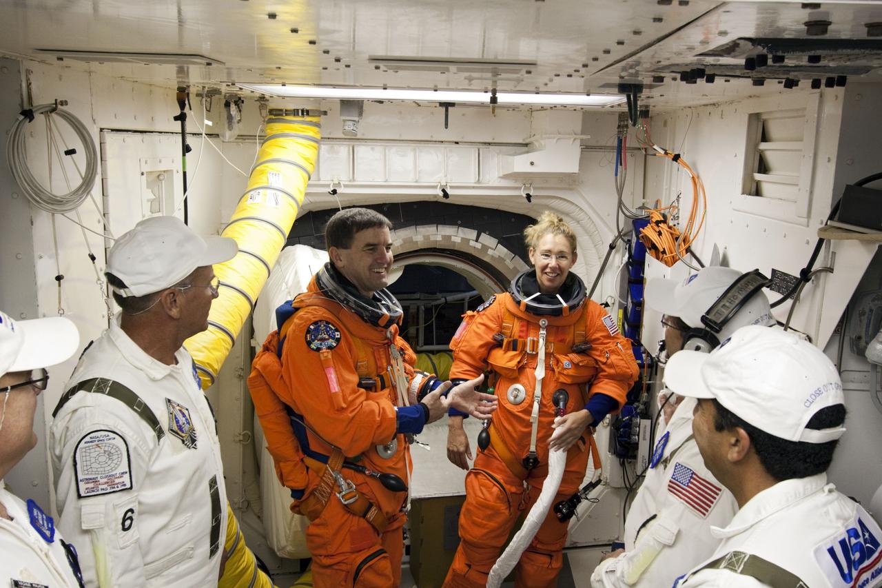 CAPE CANAVERAL, Fla. -- In the White Room at Launch Pad 39A at NASA's Kennedy Space Center in Florida, STS-135 Mission Specialists Rex Walheim and Sandy Magnus enjoy a light moment with the Closeout Crew before boarding space shuttle Atlantis through the crew hatch in the background. Members of the Closeout Crew, in white uniforms, are there to assist astronauts with their launch-and-entry suits and the boarding process. Seen in the background is Mission Specialist Sandy Magnus speaking with a Closeout Crew member. The STS-135 crew is at the pad to participate in a launch countdown simulation exercise.              As part of the Terminal Countdown Demonstration Test (TCDT), the crew members are strapped into their seats on Atlantis to practice the steps that will be taken on launch day. Shuttle Atlantis and its crew are targeted to lift off July 8, taking with them the Raffaello multi-purpose logistics module packed with supplies and spare parts to the International Space Station. The STS-135 mission also will fly a system to investigate the potential for robotically refueling existing satellites and return a failed ammonia pump module to help NASA better understand the failure mechanism and improve pump designs for future systems. STS-135 will be the 33rd flight of Atlantis, the 37th shuttle mission to the space station, and the 135th and final mission of NASA's Space Shuttle Program. For more information visit, www.nasa.gov/mission_pages/shuttle/shuttlemissions/sts135/index.html. Photo credit: NASA/Jim Grossmann