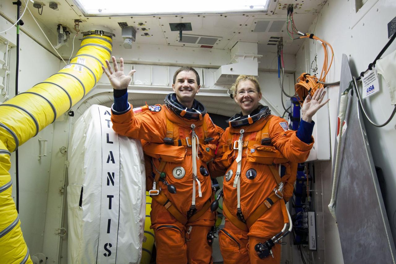 CAPE CANAVERAL, Fla. -- In the White Room at Launch Pad 39A at NASA's Kennedy Space Center in Florida, STS-135 Mission Specialists Rex Walheim and Sandy Magnus pause for a photo before boarding space shuttle Atlantis through the crew hatch in the background. The astronauts are at the pad to participate in a launch countdown simulation exercise.            As part of the Terminal Countdown Demonstration Test (TCDT), the crew members are strapped into their seats on Atlantis to practice the steps that will be taken on launch day. Shuttle Atlantis and its crew are targeted to lift off July 8, taking with them the Raffaello multi-purpose logistics module packed with supplies and spare parts to the International Space Station. The STS-135 mission also will fly a system to investigate the potential for robotically refueling existing satellites and return a failed ammonia pump module to help NASA better understand the failure mechanism and improve pump designs for future systems. STS-135 will be the 33rd flight of Atlantis, the 37th shuttle mission to the space station, and the 135th and final mission of NASA's Space Shuttle Program. For more information visit, www.nasa.gov/mission_pages/shuttle/shuttlemissions/sts135/index.html. Photo credit: NASA/Jim Grossmann