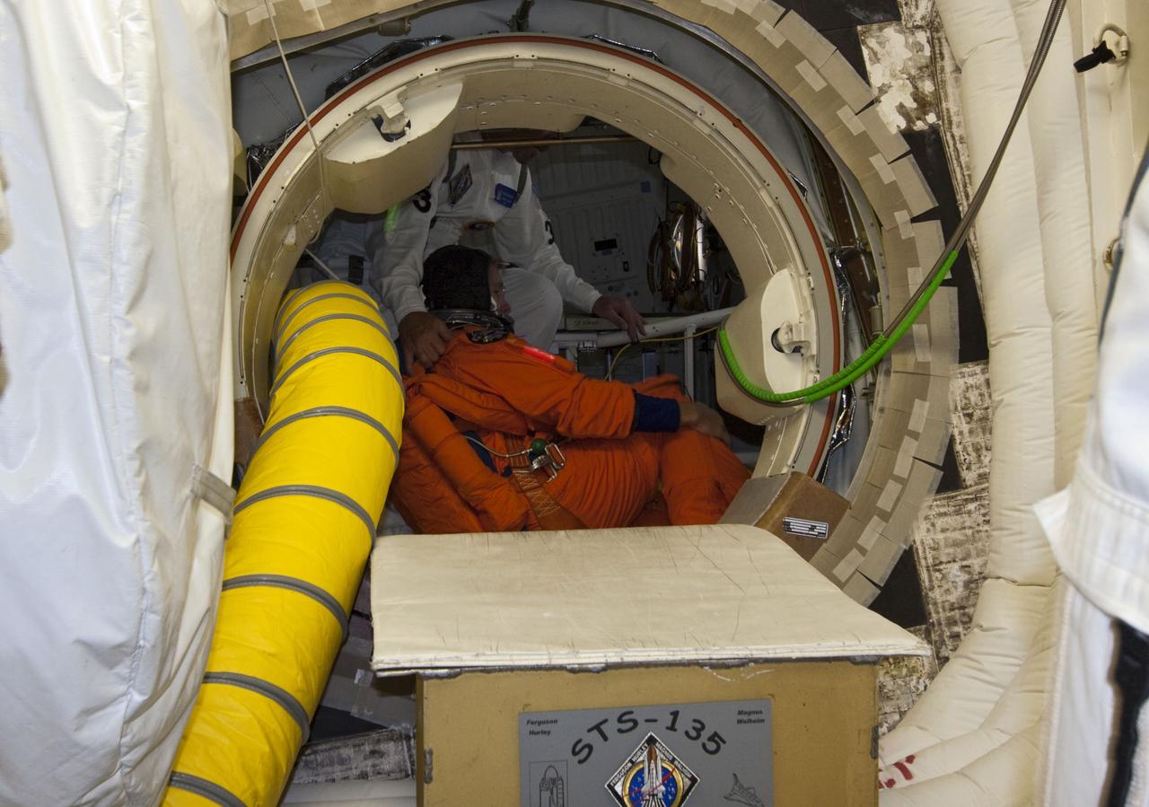CAPE CANAVERAL, Fla. -- In the White Room at Launch Pad 39A at NASA's Kennedy Space Center in Florida, STS-135 Mission Specialist Sandy Magnus gets assistance boarding space shuttle Atlantis through the crew hatch. Members of the Closeout Crew, in white uniforms, are there to assist astronauts with their launch-and-entry suits and the boarding process. The STS-135 crew members are at the pad to participate in a launch countdown simulation exercise.          As part of the Terminal Countdown Demonstration Test (TCDT), the crew members are strapped into their seats on Atlantis to practice the steps that will be taken on launch day. Shuttle Atlantis and its crew are targeted to lift off July 8, taking with them the Raffaello multi-purpose logistics module packed with supplies and spare parts to the International Space Station. The STS-135 mission also will fly a system to investigate the potential for robotically refueling existing satellites and return a failed ammonia pump module to help NASA better understand the failure mechanism and improve pump designs for future systems. STS-135 will be the 33rd flight of Atlantis, the 37th shuttle mission to the space station, and the 135th and final mission of NASA's Space Shuttle Program. For more information visit, www.nasa.gov/mission_pages/shuttle/shuttlemissions/sts135/index.html. Photo credit: NASA/Jim Grossmann