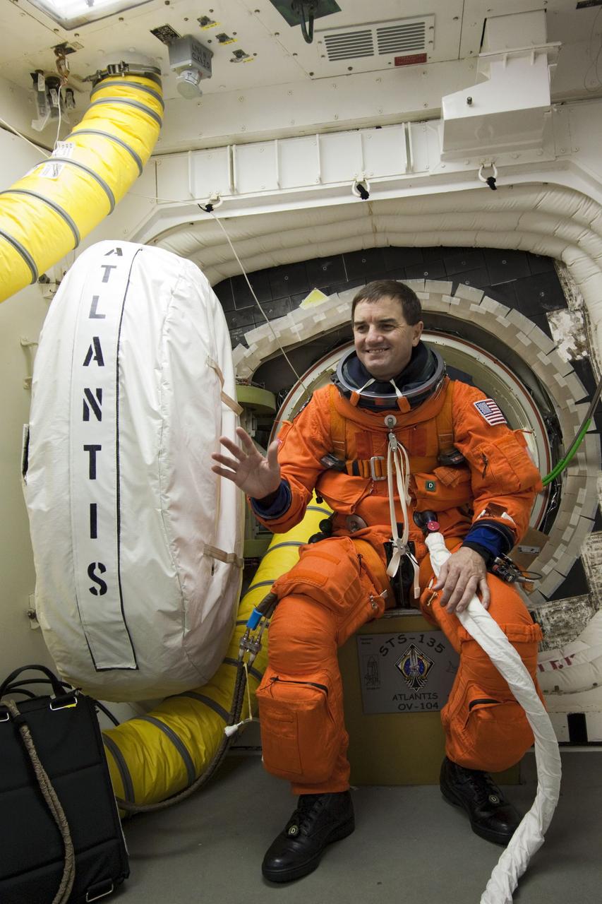 CAPE CANAVERAL, Fla. -- In the White Room at Launch Pad 39A at NASA's Kennedy Space Center in Florida, STS-135 Mission Specialist Rex Walheim pauses for a photo before boarding space shuttle Atlantis through the crew hatch in the background. The astronauts are at the pad to participate in a launch countdown simulation exercise.        As part of the Terminal Countdown Demonstration Test (TCDT), the crew members are strapped into their seats on Atlantis to practice the steps that will be taken on launch day. Shuttle Atlantis and its crew are targeted to lift off July 8, taking with them the Raffaello multi-purpose logistics module packed with supplies and spare parts to the International Space Station. The STS-135 mission also will fly a system to investigate the potential for robotically refueling existing satellites and return a failed ammonia pump module to help NASA better understand the failure mechanism and improve pump designs for future systems. STS-135 will be the 33rd flight of Atlantis, the 37th shuttle mission to the space station, and the 135th and final mission of NASA's Space Shuttle Program. For more information visit, www.nasa.gov/mission_pages/shuttle/shuttlemissions/sts135/index.html. Photo credit: NASA/Jim Grossmann