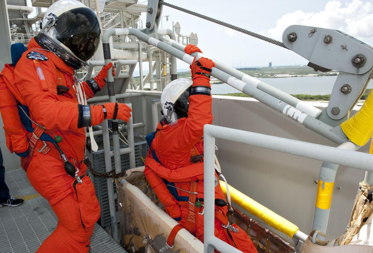 CAPE CANAVERAL, Fla. -- During simulated pad emergency exit training on Launch Pad 39A at NASA's Kennedy Space Center in Florida, the STS-135 crew members hop into a slidewire basket that would take them to a safe bunker below the pad in the unlikely event of an emergency.         The exercise is part of the Terminal Countdown Demonstration Test (TCDT) and related training. Atlantis and its crew are targeted to lift off July 8, taking with them the Raffaello multi-purpose logistics module packed with supplies and spare parts to the International Space Station. The STS-135 mission also will fly a system to investigate the potential for robotically refueling existing satellites and return a failed ammonia pump module to help NASA better understand the failure mechanism and improve pump designs for future systems. STS-135 will be the 33rd flight of Atlantis, the 37th shuttle mission to the space station, and the 135th and final mission of NASA's Space Shuttle Program. For more information visit, www.nasa.gov/mission_pages/shuttle/shuttlemissions/sts135/index.html. Photo credit: NASA/Kim Shiflett