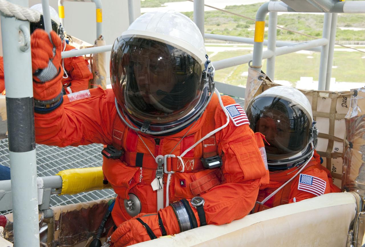 CAPE CANAVERAL, Fla. -- During simulated pad emergency exit training on Launch Pad 39A at NASA's Kennedy Space Center in Florida, STS-135 Commander Chris Ferguson (left) and Pilot Doug Hurley position themselves in a slidewire basket that would take them to a safe bunker below the pad in the unlikely event of an emergency.       The exercise is part of the Terminal Countdown Demonstration Test (TCDT) and related training. Atlantis and its crew are targeted to lift off July 8, taking with them the Raffaello multi-purpose logistics module packed with supplies and spare parts to the International Space Station. The STS-135 mission also will fly a system to investigate the potential for robotically refueling existing satellites and return a failed ammonia pump module to help NASA better understand the failure mechanism and improve pump designs for future systems. STS-135 will be the 33rd flight of Atlantis, the 37th shuttle mission to the space station, and the 135th and final mission of NASA's Space Shuttle Program. For more information visit, www.nasa.gov/mission_pages/shuttle/shuttlemissions/sts135/index.html. Photo credit: NASA/Kim Shiflett