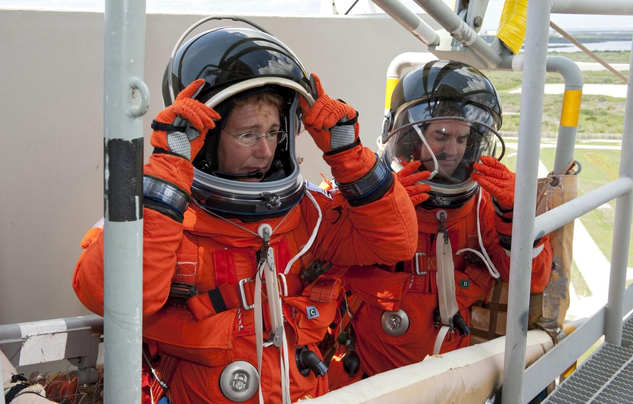 CAPE CANAVERAL, Fla. -- During simulated pad emergency exit training on Launch Pad 39A at NASA's Kennedy Space Center in Florida, STS-135 Mission Specialists Sandy Magnus (left) and Rex Walheim position themselves in a slidewire basket that would take them to a safe bunker below the pad in the unlikely event of an emergency.            The exercise is part of the Terminal Countdown Demonstration Test (TCDT) and related training. Atlantis and its crew are targeted to lift off July 8, taking with them the Raffaello multi-purpose logistics module packed with supplies and spare parts to the International Space Station. The STS-135 mission also will fly a system to investigate the potential for robotically refueling existing satellites and return a failed ammonia pump module to help NASA better understand the failure mechanism and improve pump designs for future systems. STS-135 will be the 33rd flight of Atlantis, the 37th shuttle mission to the space station, and the 135th and final mission of NASA's Space Shuttle Program. For more information visit, www.nasa.gov/mission_pages/shuttle/shuttlemissions/sts135/index.html. Photo credit: NASA/Kim Shiflett