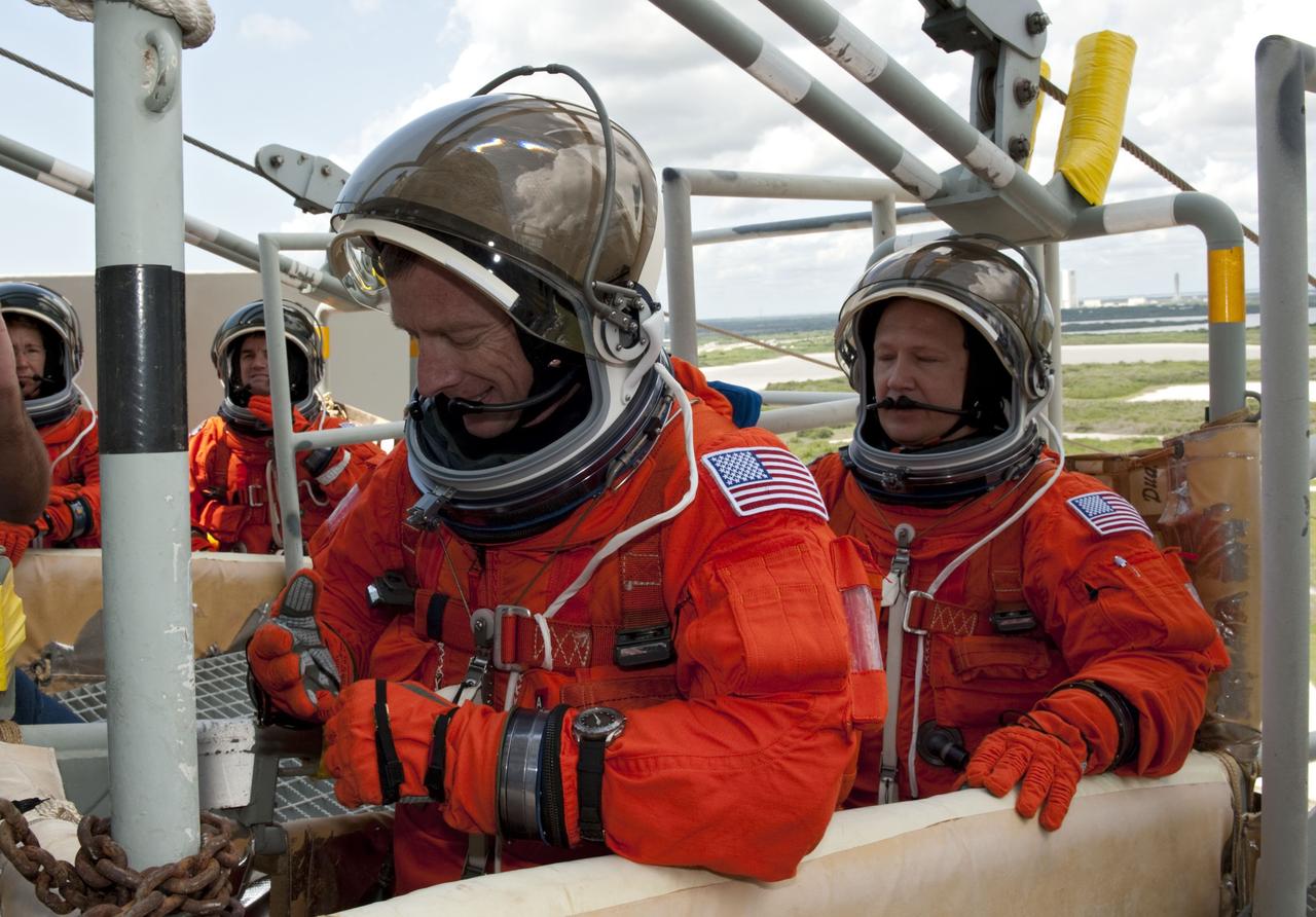 CAPE CANAVERAL, Fla. -- During simulated pad emergency exit training on Launch Pad 39A at NASA's Kennedy Space Center in Florida, STS-135 Commander Chris Ferguson (left) and Pilot Doug Hurley position themselves in a slidewire basket that would take them to a safe bunker below the pad in the unlikely event of an emergency.            The exercise is part of the Terminal Countdown Demonstration Test (TCDT) and related training. Atlantis and its crew are targeted to lift off July 8, taking with them the Raffaello multi-purpose logistics module packed with supplies and spare parts to the International Space Station. The STS-135 mission also will fly a system to investigate the potential for robotically refueling existing satellites and return a failed ammonia pump module to help NASA better understand the failure mechanism and improve pump designs for future systems. STS-135 will be the 33rd flight of Atlantis, the 37th shuttle mission to the space station, and the 135th and final mission of NASA's Space Shuttle Program. For more information visit, www.nasa.gov/mission_pages/shuttle/shuttlemissions/sts135/index.html. Photo credit: NASA/Kim Shiflett