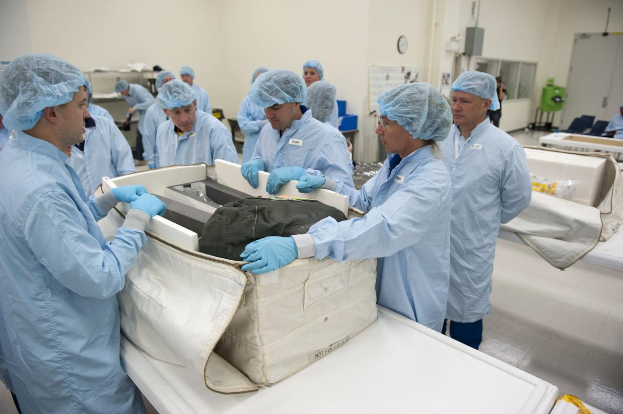 CAPE CANAVERAL, Fla. -- During the bench review of systems and hardware in the Space Station Processing Facility at NASA's Kennedy Space Center in Florida, space shuttle Atlantis' STS-135 crew members get a close look at some of the equipment they'll use in space. The astronauts dressed in clean-room attire, known as "bunny suits" are (from right to left) Mission Specialist Sandy Magnus, Pilot Doug Hurley, Mission Specialist Rex Walheim and Commander Chris Ferguson.              The review is part of the Terminal Countdown Demonstration Test (TCDT) and related training. Atlantis and its crew are targeted to lift off July 8, taking with them the Raffaello multi-purpose logistics module packed with supplies and spare parts to the International Space Station. The STS-135 mission also will fly a system to investigate the potential for robotically refueling existing satellites and return a failed ammonia pump module to help NASA better understand the failure mechanism and improve pump designs for future systems. STS-135 will be the 33rd flight of Atlantis, the 37th shuttle mission to the space station, and the 135th and final mission of NASA's Space Shuttle Program. For more information visit, www.nasa.gov/mission_pages/shuttle/shuttlemissions/sts135/index.html. Photo credit: NASA/Kim Shiflett