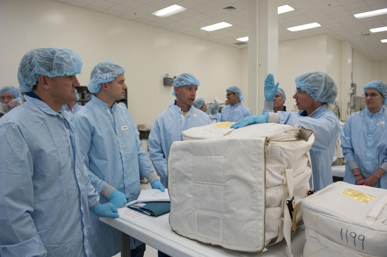 CAPE CANAVERAL, Fla. -- During the bench review of systems and hardware in the Space Station Processing Facility at NASA's Kennedy Space Center in Florida, space shuttle Atlantis' STS-135 crew members get a close look at some of the equipment they'll use in space. The astronauts dressed in clean-room attire, known as "bunny suits" are Mission Specialist Rex Walheim (left), a technician, Commander Chris Ferguson and Mission Specialist Sandy Magnus.          The review is part of the Terminal Countdown Demonstration Test (TCDT) and related training. Atlantis and its crew are targeted to lift off July 8, taking with them the Raffaello multi-purpose logistics module packed with supplies and spare parts to the International Space Station. The STS-135 mission also will fly a system to investigate the potential for robotically refueling existing satellites and return a failed ammonia pump module to help NASA better understand the failure mechanism and improve pump designs for future systems. STS-135 will be the 33rd flight of Atlantis, the 37th shuttle mission to the space station, and the 135th and final mission of NASA's Space Shuttle Program. For more information visit, www.nasa.gov/mission_pages/shuttle/shuttlemissions/sts135/index.html. Photo credit: NASA/Kim Shiflett