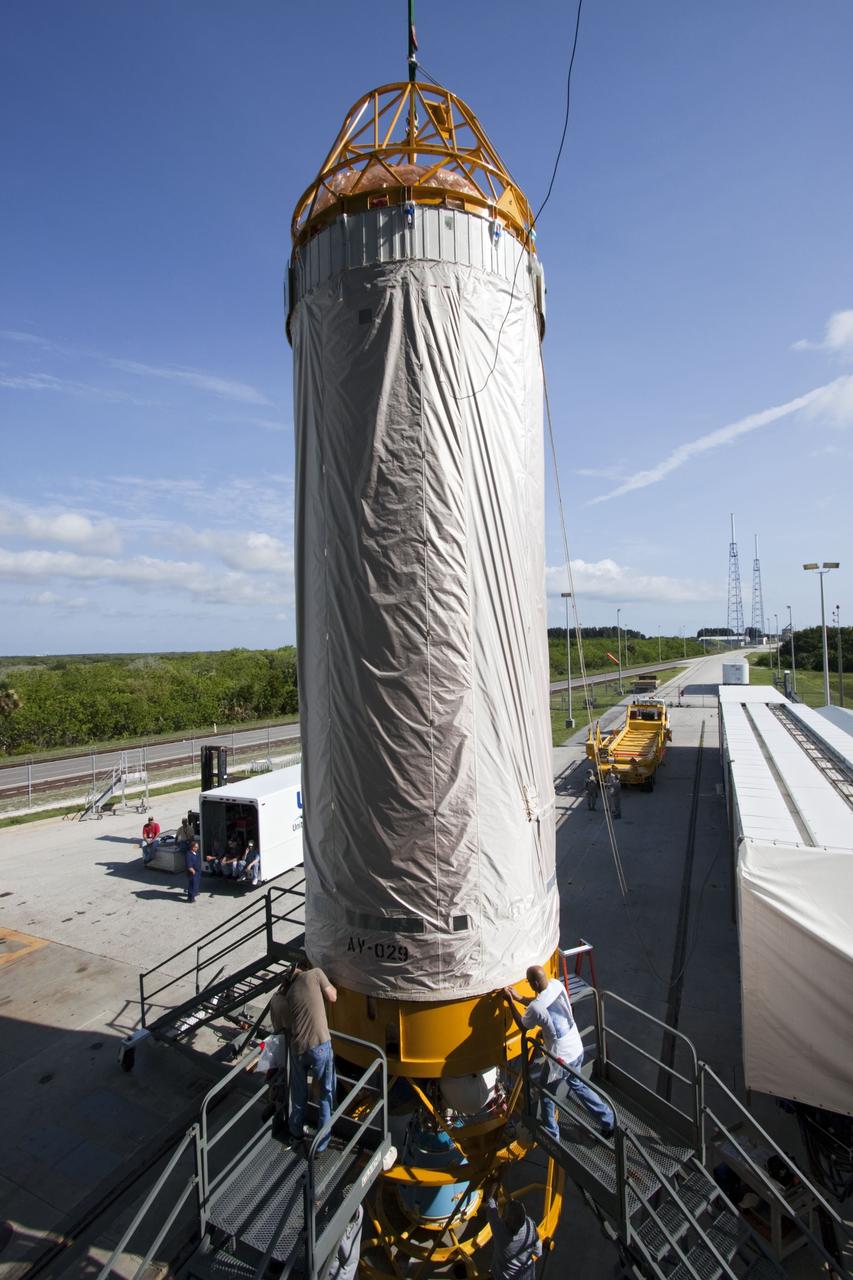 CAPE CANAVERAL, Fla. -- At Launch Complex 41 at Cape Canaveral Air Force Station in Florida, workers roll down the protective cover on the Centaur upper stage for the United Launch Alliance Atlas V, slated to launch NASA's Juno spacecraft, as it lifted into the Vertical Integration Facility (VIF). After in position in the VIF it will be attached to the Atlas V booster stage, already at the pad. Juno is scheduled to launch aboard an Atlas V from Cape Canaveral, Fla. Aug. 5.The solar-powered spacecraft will orbit Jupiter's poles 33 times to find out more about the gas giant's origins, structure, atmosphere and magnetosphere and investigate the existence of a solid planetary core. For more information visit: www.nasa.gov/juno. Photo credit: NASA/Jim Grossmann