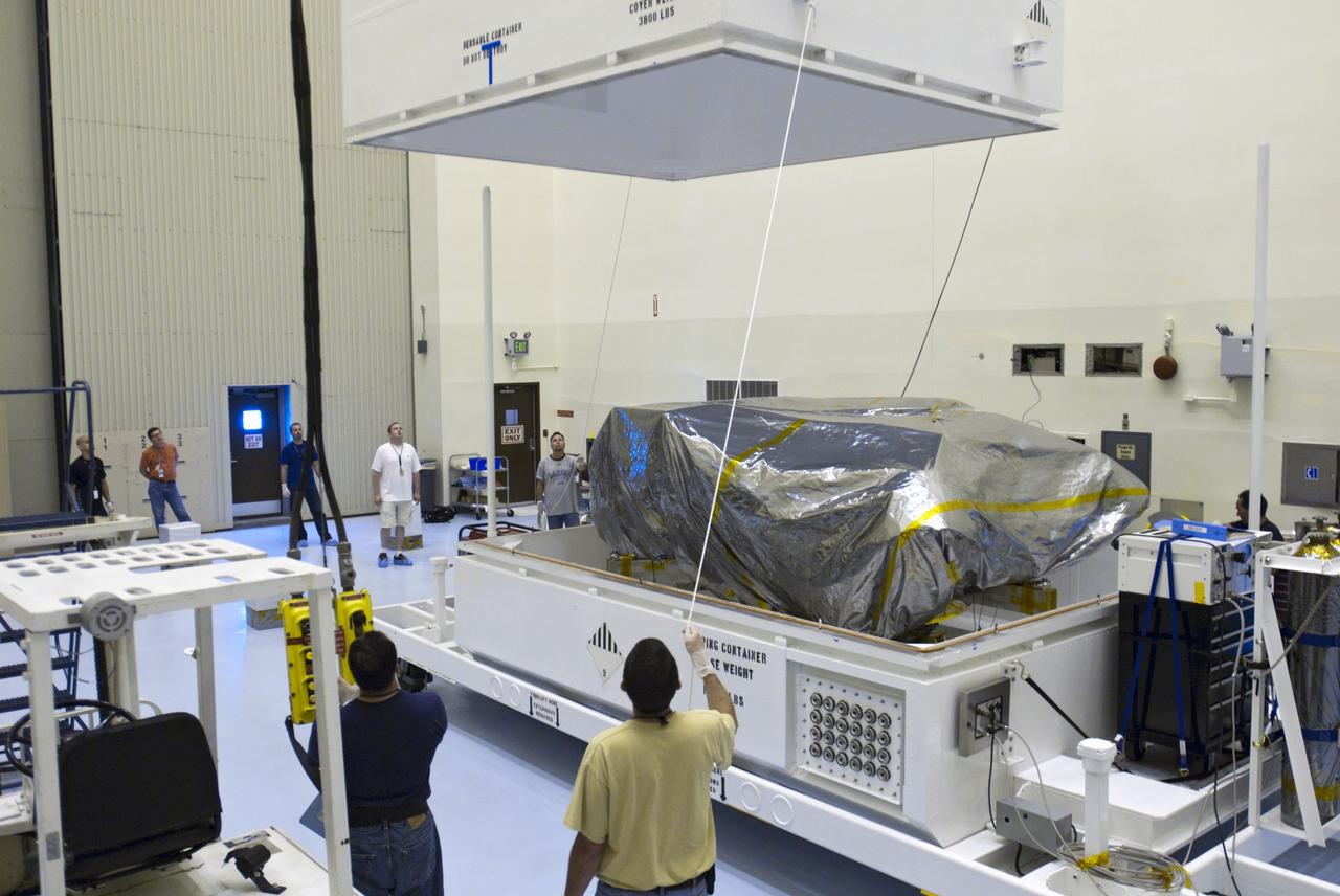 Cape Canaveral, Fla. -- At the Payload Hazardous Servicing Facility at NASA's Kennedy Space Center in Florida, workers using an overhead crane lift the container cover from NASA's Mars Science Laboratory (MSL) rover, known as Curiosity. A United Launch Alliance Atlas V-541 configuration will be used to loft MSL into space. Curiosity’s 10 science instruments are designed to search for evidence on whether Mars has had environments favorable to microbial life, including chemical ingredients for life. The unique rover will use a laser to look inside rocks and release its gasses so that the rover’s spectrometer can analyze and send the data back to Earth. MSL is scheduled to launch from Cape Canaveral Air Force Station in Florida Nov. 25 with a window extending to Dec. 18 and arrival at Mars Aug. 2012. For more information, visit http://www.nasa.gov/msl. Photo credit: NASA/Charisse Nahser