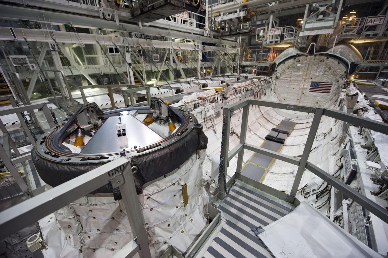 CAPE CANAVERAL, Fla. -- In Orbiter Processing Facility-1 at NASA's Kennedy Space Center in Florida, workers are disconnecting and dismantling components on shuttle Endeavour. Seen here is the spacecraft's docking port in the payload bay. The work is part of Endeavour's transition and retirement processing. The spacecraft is being prepared for public display at the California Science Center in Los Angeles. Endeavour flew 25 missions, spent 299 days in space, orbited Earth 4,671 times and traveled 122,883,151 miles over the course of its 19-year career. Endeavour's STS-134 and final mission was completed after landing on June 1, 2011. Photo credit: NASA/Kim Shiflett