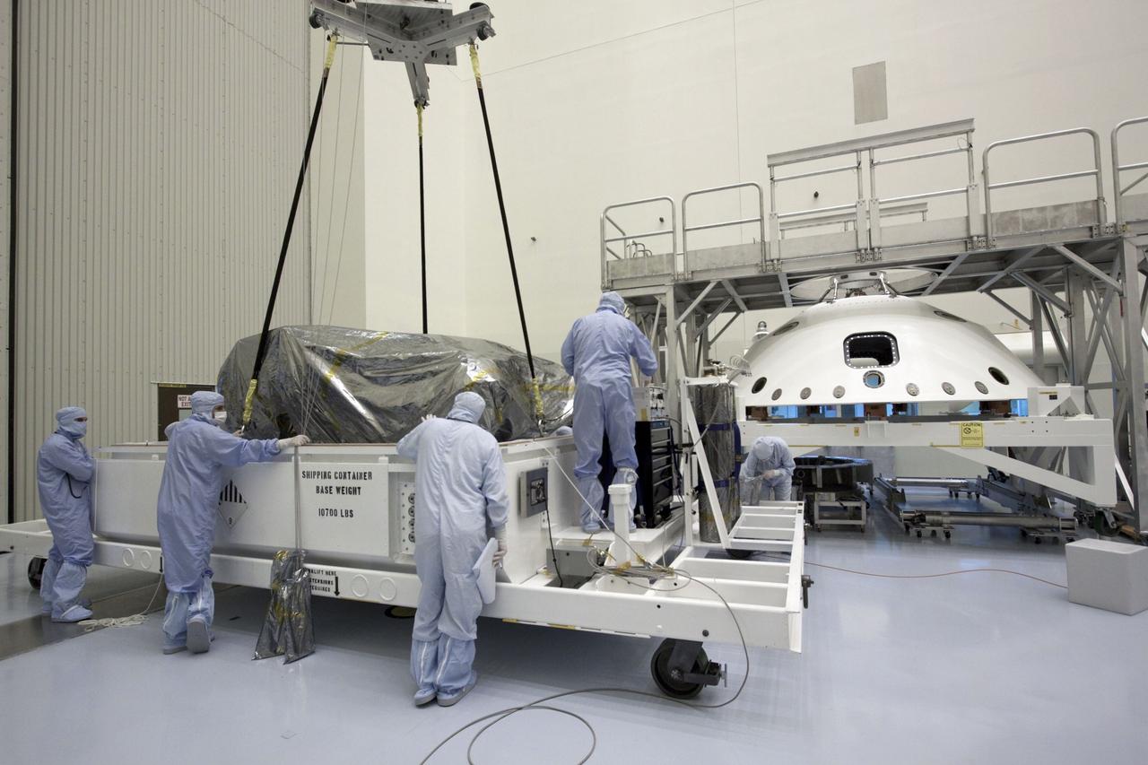 Cape Canaveral, Fla. -- At the Payload Hazardous Servicing Facility at NASA's Kennedy Space Center in Florida, technicians attach an overhead crane to NASA's Mars Science Laboratory (MSL) rover known as Curiosity, for its move to a work stand. The spacecraft's backshell (right), which carries the parachute and several components used during later stages of entry, descent and landing, also is visible in the image.        A United Launch Alliance Atlas V-541 configuration will be used to loft MSL into space. Curiosity’s 10 science instruments are designed to search for evidence on whether Mars has had environments favorable to microbial life, including chemical ingredients for life.  The unique rover will use a laser to look inside rocks and release its gasses so that the rover’s spectrometer can analyze and send the data back to Earth. MSL is scheduled to launch from Cape Canaveral Air Force Station in Florida Nov. 25 with a window extending to Dec. 18 and arrival at Mars Aug. 2012. For more information, visit http://www.nasa.gov/msl. Photo credit: NASA/Jim Grossmann