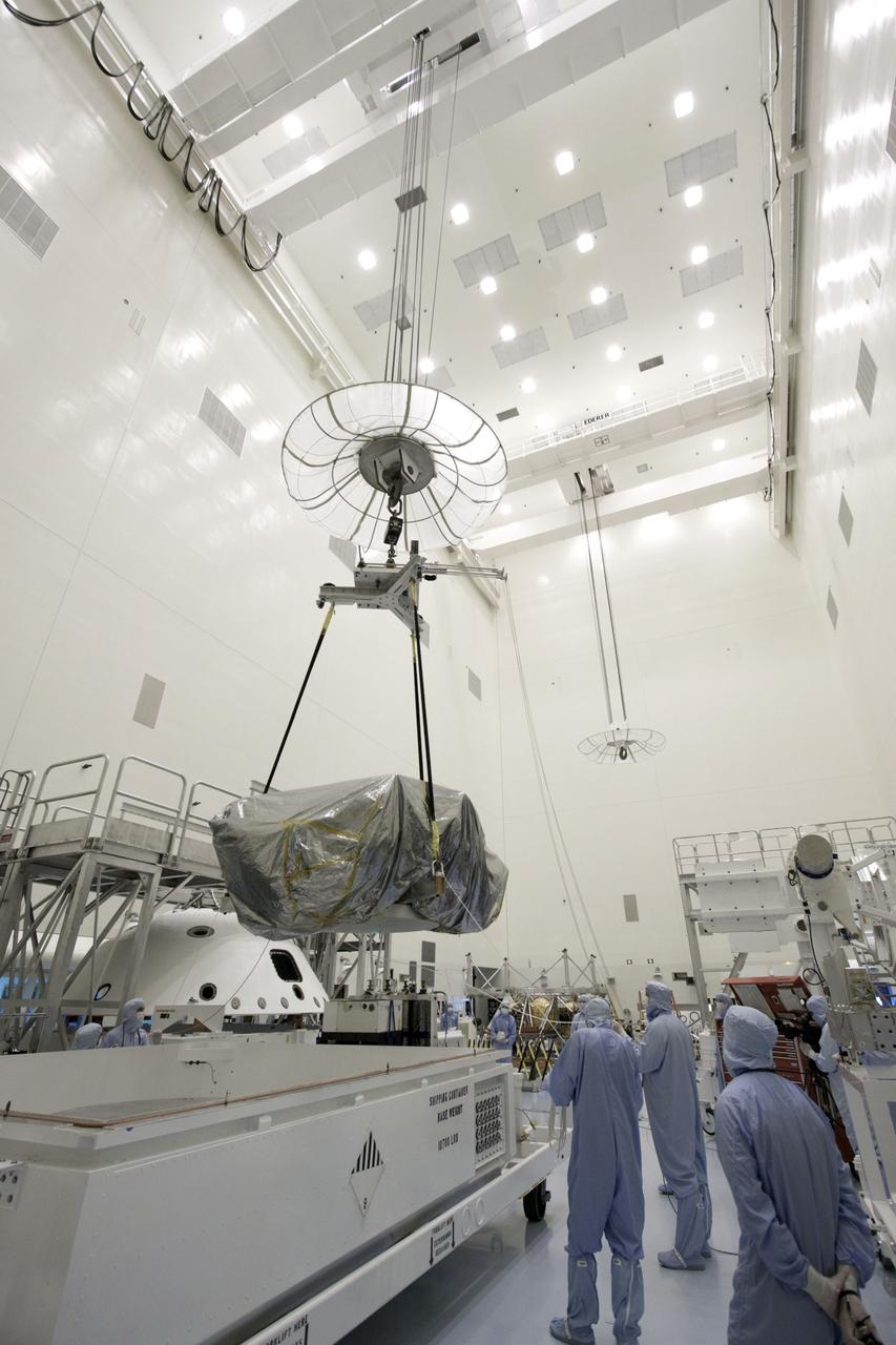 Cape Canaveral, Fla. -- At the Payload Hazardous Servicing Facility at NASA's Kennedy Space Center in Florida, technicians use an overhead crane to move NASA's Mars Science Laboratory (MSL) rover known as Curiosity, to a work stand. The spacecraft's backshell (left), which carries the parachute and several components used during later stages of entry, descent and landing, in addition is the rocket-powered descent stage (far background), also visible in the image.        A United Launch Alliance Atlas V-541 configuration will be used to loft MSL into space. Curiosity’s 10 science instruments are designed to search for evidence on whether Mars has had environments favorable to microbial life, including chemical ingredients for life.  The unique rover will use a laser to look inside rocks and release its gasses so that the rover’s spectrometer can analyze and send the data back to Earth. MSL is scheduled to launch from Cape Canaveral Air Force Station in Florida Nov. 25 with a window extending to Dec. 18 and arrival at Mars Aug. 2012. For more information, visit http://www.nasa.gov/msl. Photo credit: NASA/Jim Grossmann