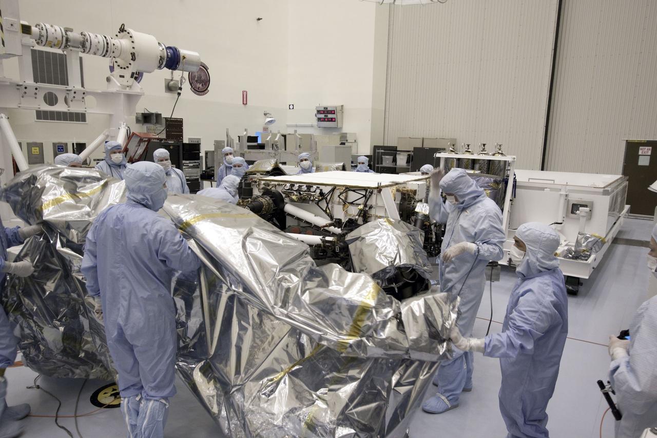 Cape Canaveral, Fla. -- At the Payload Hazardous Servicing Facility at NASA's Kennedy Space Center in Florida, technicians remove the protective cover from NASA's Mars Science Laboratory (MSL) rover known as Curiosity, before processing and testing.      A United Launch Alliance Atlas V-541 configuration will be used to loft MSL into space. Curiosity’s 10 science instruments are designed to search for evidence on whether Mars has had environments favorable to microbial life, including chemical ingredients for life.  The unique rover will use a laser to look inside rocks and release its gasses so that the rover’s spectrometer can analyze and send the data back to Earth. MSL is scheduled to launch from Cape Canaveral Air Force Station in Florida Nov. 25 with a window extending to Dec. 18 and arrival at Mars Aug. 2012. For more information, visit http://www.nasa.gov/msl. Photo credit: NASA/Jim Grossmann