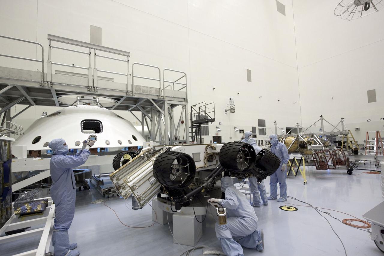 Cape Canaveral, Fla. -- At the Payload Hazardous Servicing Facility at NASA's Kennedy Space Center in Florida, NASA's Mars Science Laboratory (MSL) rover known as Curiosity, is secured on a work stand for processing. The spacecraft's backshell (left), which carries the parachute and several components used during later stages of entry, descent and landing, in addition is the rocket-powered descent stage (background right), also is visible in the image.      A United Launch Alliance Atlas V-541 configuration will be used to loft MSL into space. Curiosity’s 10 science instruments are designed to search for evidence on whether Mars has had environments favorable to microbial life, including chemical ingredients for life.  The unique rover will use a laser to look inside rocks and release its gasses so that the rover’s spectrometer can analyze and send the data back to Earth. MSL is scheduled to launch from Cape Canaveral Air Force Station in Florida Nov. 25 with a window extending to Dec. 18 and arrival at Mars Aug. 2012. For more information, visit http://www.nasa.gov/msl. Photo credit: NASA/Jim Grossmann