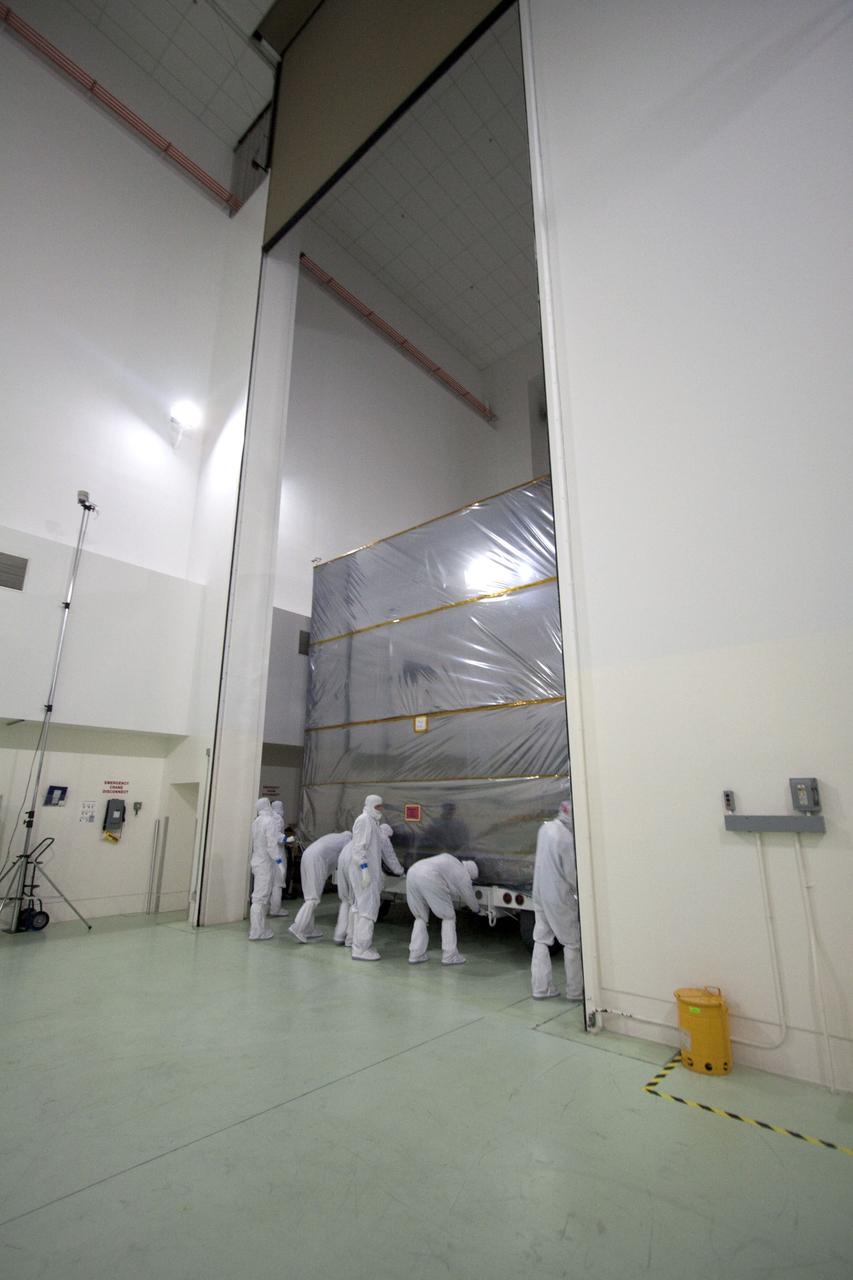 CAPE CANAVERAL, Fla., -- At the Astrotech Payload Processing Facility in Titusville, Fla., technicians stretch a protective cover over NASA's Juno spacecraft. Juno is being prepared for its move to the Hazardous Processing Facility for fueling. The spacecraft will be loaded with the propellant necessary for orbit maneuvers and the attitude control system. Juno is scheduled to launch aboard a United Launch Alliance Atlas V rocket from Cape Canaveral, Fla., Aug. 5.The solar-powered spacecraft will orbit Jupiter's poles 33 times to find out more about the gas giant's origins, structure, atmosphere and magnetosphere and investigate the existence of a solid planetary core. For more information visit: www.nasa.gov/juno. Photo credit: NASA/Troy Cryder