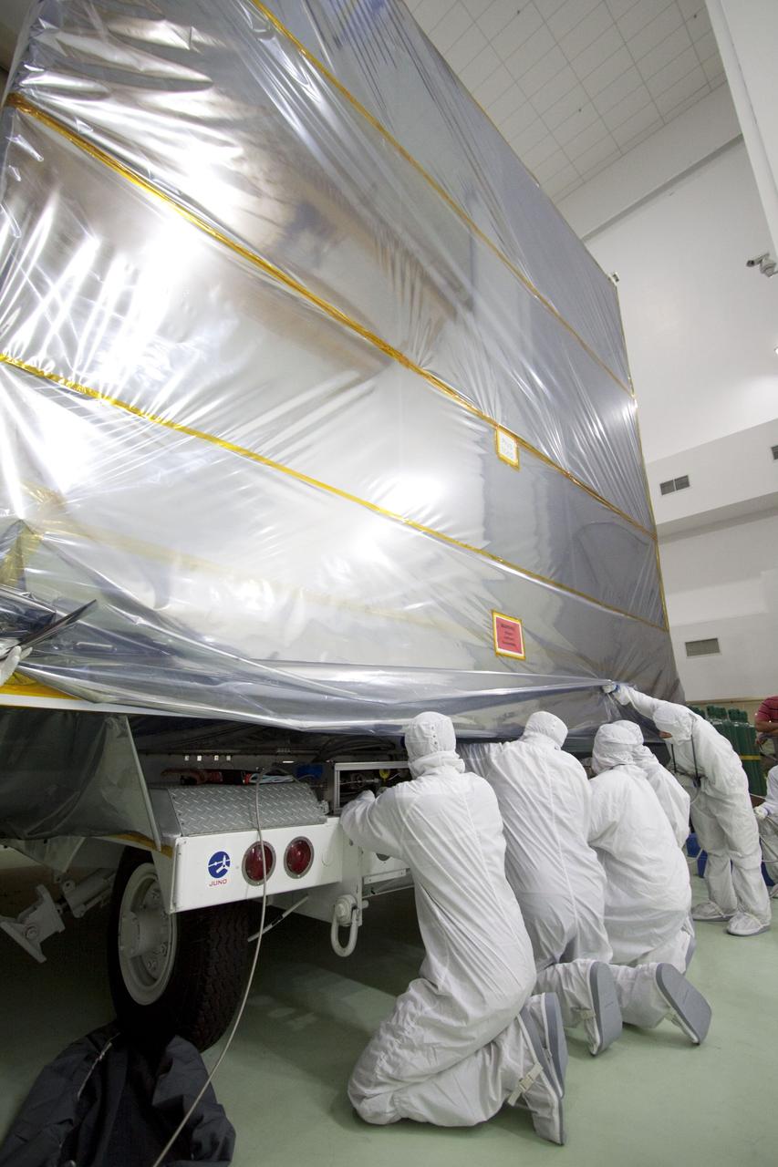 CAPE CANAVERAL, Fla. -- At the Astrotech Payload Processing Facility in Titusville, Fla., , technicians secure a protective cover over NASA's Juno spacecraft. Juno is being prepared for its move to the Hazardous Processing Facility for fueling. The spacecraft will be loaded with the propellant necessary for orbit maneuvers and the attitude control system.          Juno is scheduled to launch aboard a United Launch Alliance Atlas V rocket from Cape Canaveral, Fla.,  Aug. 5.The solar-powered spacecraft will orbit Jupiter's poles 33 times to find out more about the gas giant's origins, structure, atmosphere and magnetosphere and investigate the existence of a solid planetary core. For more information visit: www.nasa.gov/juno. Photo credit: NASA/Troy Cryder