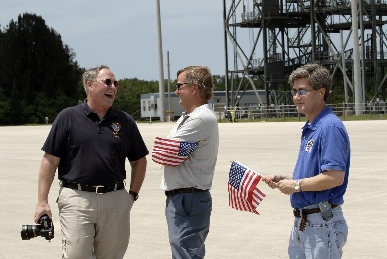 CAPE CANAVERAL, Fla. -- Jerry Ross, chief of the Vehicle Integration Test Office and former NASA astronaut, Shuttle Launch Director Mike Leinbach and James Branson with the Vehicle Integration Test Office await the arrival of the STS-135 crew members at the Shuttle Landing Facility at NASA's Kennedy Space Center in Florida. The STS-135 astronauts arrived at Kennedy about 2:30 p.m. EDT on July 4 for final preparations for space shuttle Atlantis' STS-135 mission to the International Space Station. Atlantis is scheduled to lift off on July 8 to deliver the Raffaello multi-purpose logistics module packed with supplies and spare parts to the station. The STS-135 mission also will fly a system to investigate the potential for robotically refueling existing satellites and return a failed ammonia pump module to help NASA better understand the failure mechanism and improve pump designs for future systems. STS-135 will be the 33rd flight of Atlantis, the 37th shuttle mission to the space station, and the 135th and final mission of NASA's Space Shuttle Program. For more information visit, www.nasa.gov/mission_pages/shuttle/shuttlemissions/sts135/index.html. Photo credit: NASA/Kim Shiflett