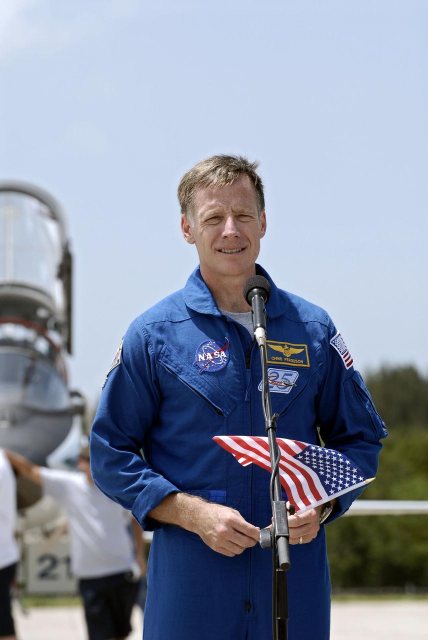 CAPE CANAVERAL, Fla. -- STS-135 Commander Chris Ferguson, holding an American flag to commemorate the U.S. Independence Day holiday, speaks to media at the Shuttle Landing Facility at NASA's Kennedy Space Center in Florida. The STS-135 astronauts arrived at Kennedy about 2:30 p.m. EDT on July 4 for final preparations for space shuttle Atlantis' STS-135 mission to the International Space Station. Atlantis is scheduled to lift off on July 8 to deliver the Raffaello multi-purpose logistics module packed with supplies and spare parts to the station. The STS-135 mission also will fly a system to investigate the potential for robotically refueling existing satellites and return a failed ammonia pump module to help NASA better understand the failure mechanism and improve pump designs for future systems. STS-135 will be the 33rd flight of Atlantis, the 37th shuttle mission to the space station, and the 135th and final mission of NASA's Space Shuttle Program. For more information visit, www.nasa.gov/mission_pages/shuttle/shuttlemissions/sts135/index.html. Photo credit: NASA/Kim Shiflett