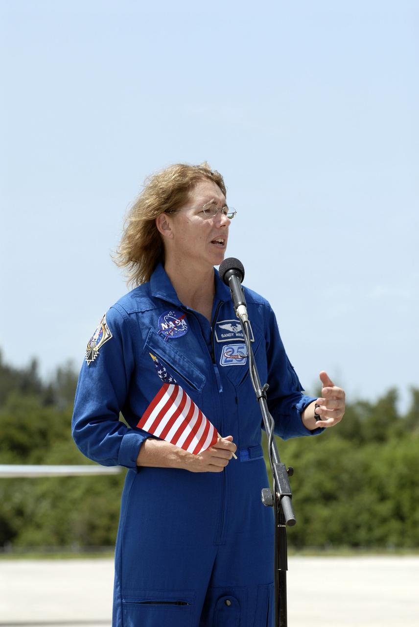 CAPE CANAVERAL, Fla. -- STS-135 Mission Specialist Sandy Magnus, holding an American flag to commemorate the U.S. Independence Day holiday, speaks to media at the Shuttle Landing Facility at NASA's Kennedy Space Center in Florida. The STS-135 astronauts arrived at Kennedy about 2:30 p.m. EDT on July 4 for final preparations for space shuttle Atlantis' STS-135 mission to the International Space Station. Atlantis is scheduled to lift off on July 8 to deliver the Raffaello multi-purpose logistics module packed with supplies and spare parts to the station. The STS-135 mission also will fly a system to investigate the potential for robotically refueling existing satellites and return a failed ammonia pump module to help NASA better understand the failure mechanism and improve pump designs for future systems. STS-135 will be the 33rd flight of Atlantis, the 37th shuttle mission to the space station, and the 135th and final mission of NASA's Space Shuttle Program. For more information visit, www.nasa.gov/mission_pages/shuttle/shuttlemissions/sts135/index.html. Photo credit: NASA/Kim Shiflett
