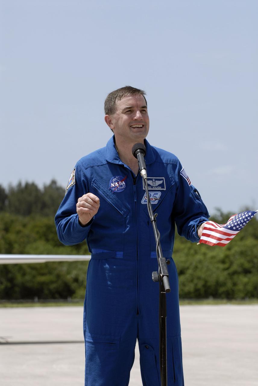 CAPE CANAVERAL, Fla. -- STS-135 Mission Specialist Rex Walheim, holding an American flag to commemorate the U.S. Independence Day holiday, speaks to media at the Shuttle Landing Facility at NASA's Kennedy Space Center in Florida. The STS-135 astronauts arrived at Kennedy about 2:30 p.m. EDT on July 4 for final preparations for space shuttle Atlantis' STS-135 mission to the International Space Station. Atlantis is scheduled to lift off on July 8 to deliver the Raffaello multi-purpose logistics module packed with supplies and spare parts to the station. The STS-135 mission also will fly a system to investigate the potential for robotically refueling existing satellites and return a failed ammonia pump module to help NASA better understand the failure mechanism and improve pump designs for future systems. STS-135 will be the 33rd flight of Atlantis, the 37th shuttle mission to the space station, and the 135th and final mission of NASA's Space Shuttle Program. For more information visit, www.nasa.gov/mission_pages/shuttle/shuttlemissions/sts135/index.html. Photo credit: NASA/Kim Shiflett