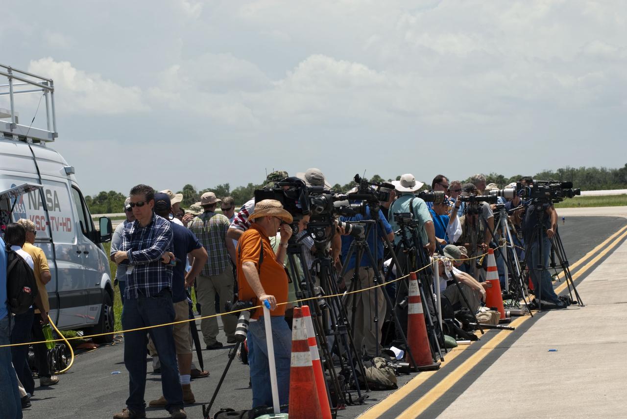 CAPE CANAVERAL, Fla. -- Media await the arrival of the STS-135 crew members at the Shuttle Landing Facility at NASA's Kennedy Space Center in Florida. The STS-135 astronauts arrived at Kennedy about 2:30 p.m. EDT on July 4 for final preparations for space shuttle Atlantis' STS-135 mission to the International Space Station. Atlantis is scheduled to lift off on July 8 to deliver the Raffaello multi-purpose logistics module packed with supplies and spare parts to the station. The STS-135 mission also will fly a system to investigate the potential for robotically refueling existing satellites and return a failed ammonia pump module to help NASA better understand the failure mechanism and improve pump designs for future systems. STS-135 will be the 33rd flight of Atlantis, the 37th shuttle mission to the space station, and the 135th and final mission of NASA's Space Shuttle Program. For more information visit, www.nasa.gov/mission_pages/shuttle/shuttlemissions/sts135/index.html. Photo credit: NASA/Jim Grossmann